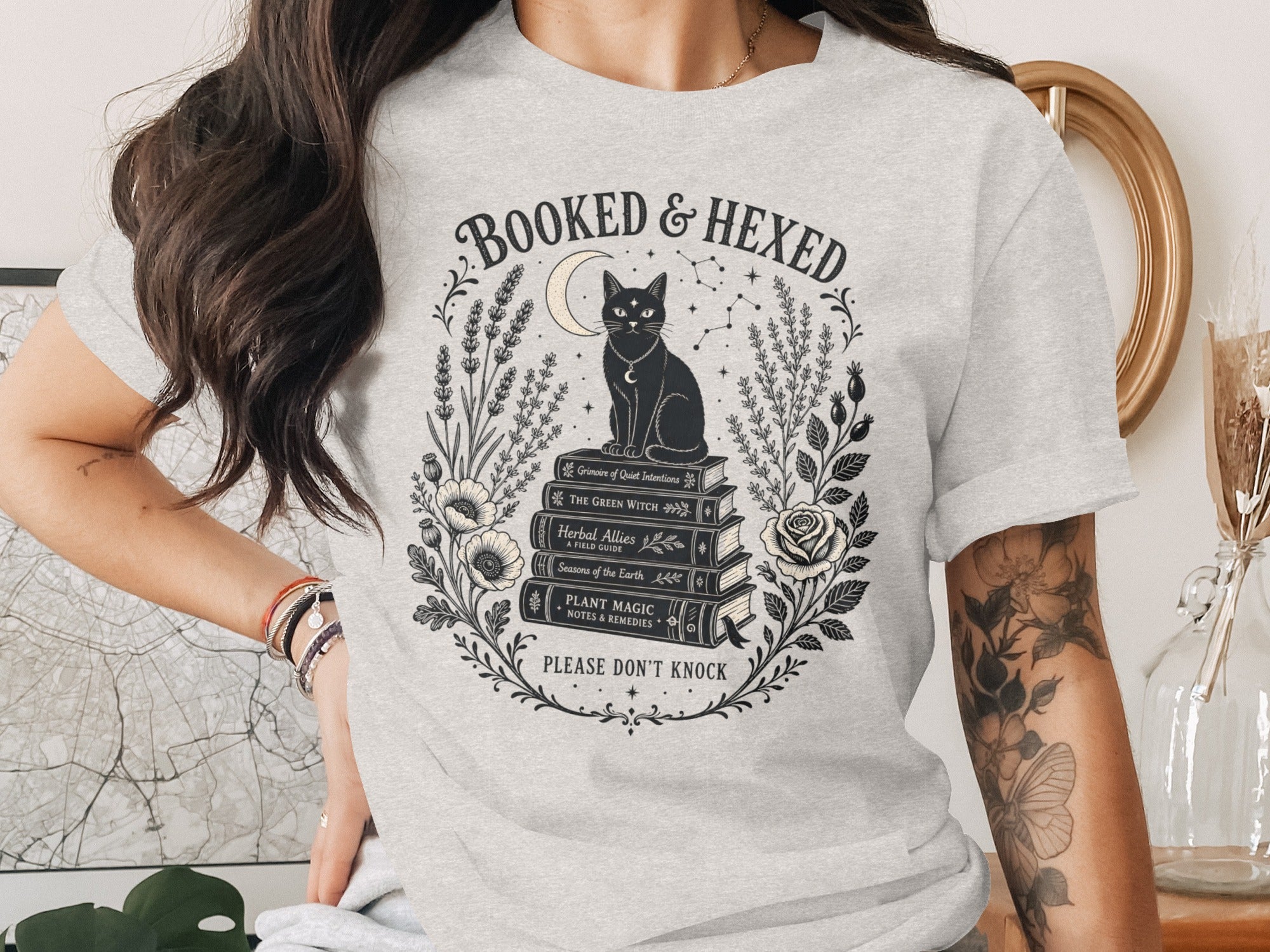 Light grey t-shirt with black graphic: "Booked & Hexed" with cat on books.