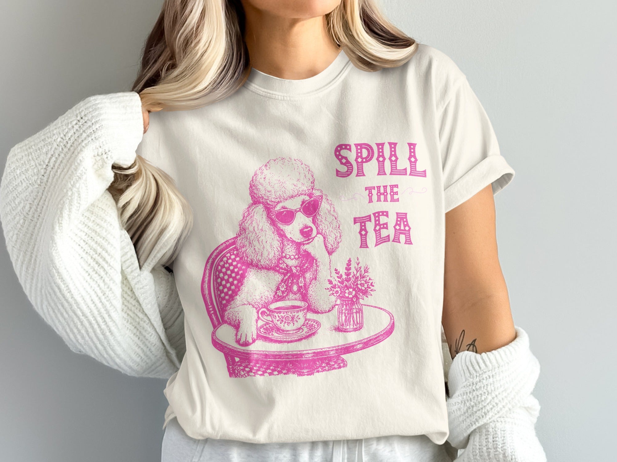 Pink graphic of a poodle wearing sunglasses, sitting at a table, with "Spill The Tea" text.