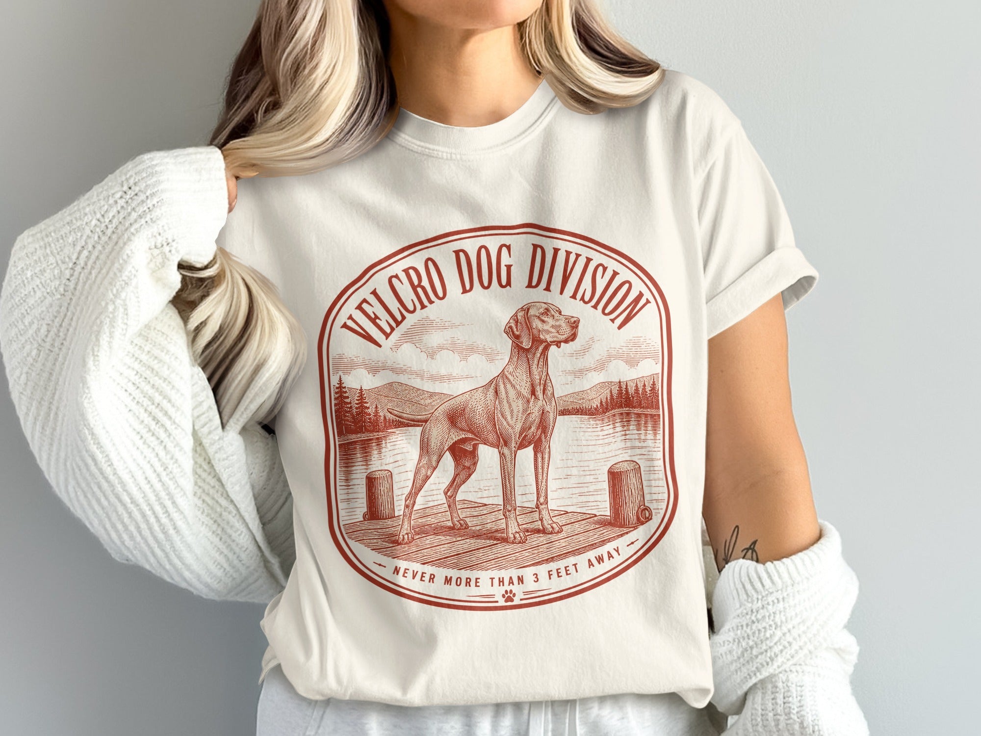 Cream t-shirt with red graphic of dog on dock, "Velcro Dog Division Never More Than 3 Feet Away".