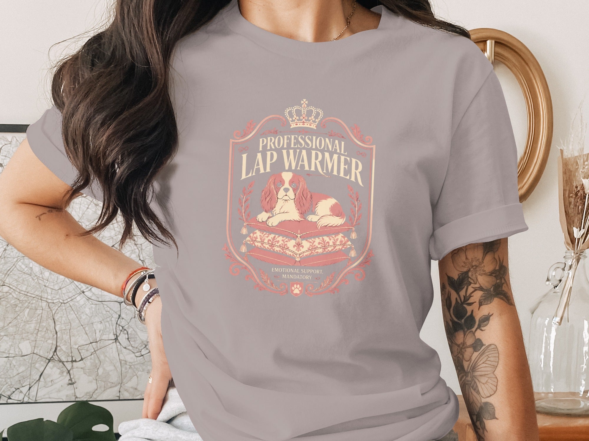 T-shirt graphic with a dog lounging on pillows, text "Professional Lap Warmer" and "Emotional Support Mandatory".