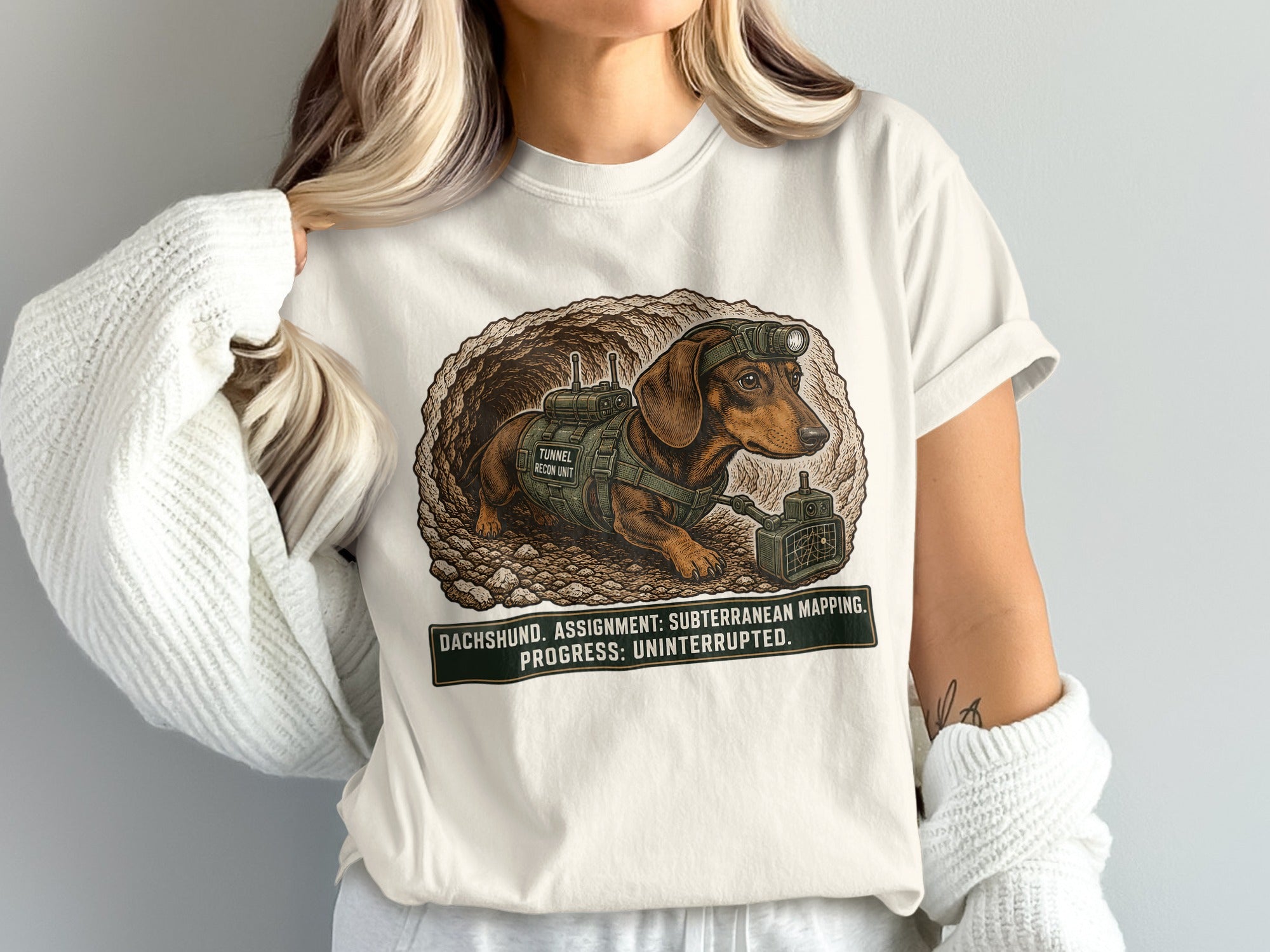 Dachshund in a tunnel wearing a headlamp and backpack with text "Tunnel Recon Unit".