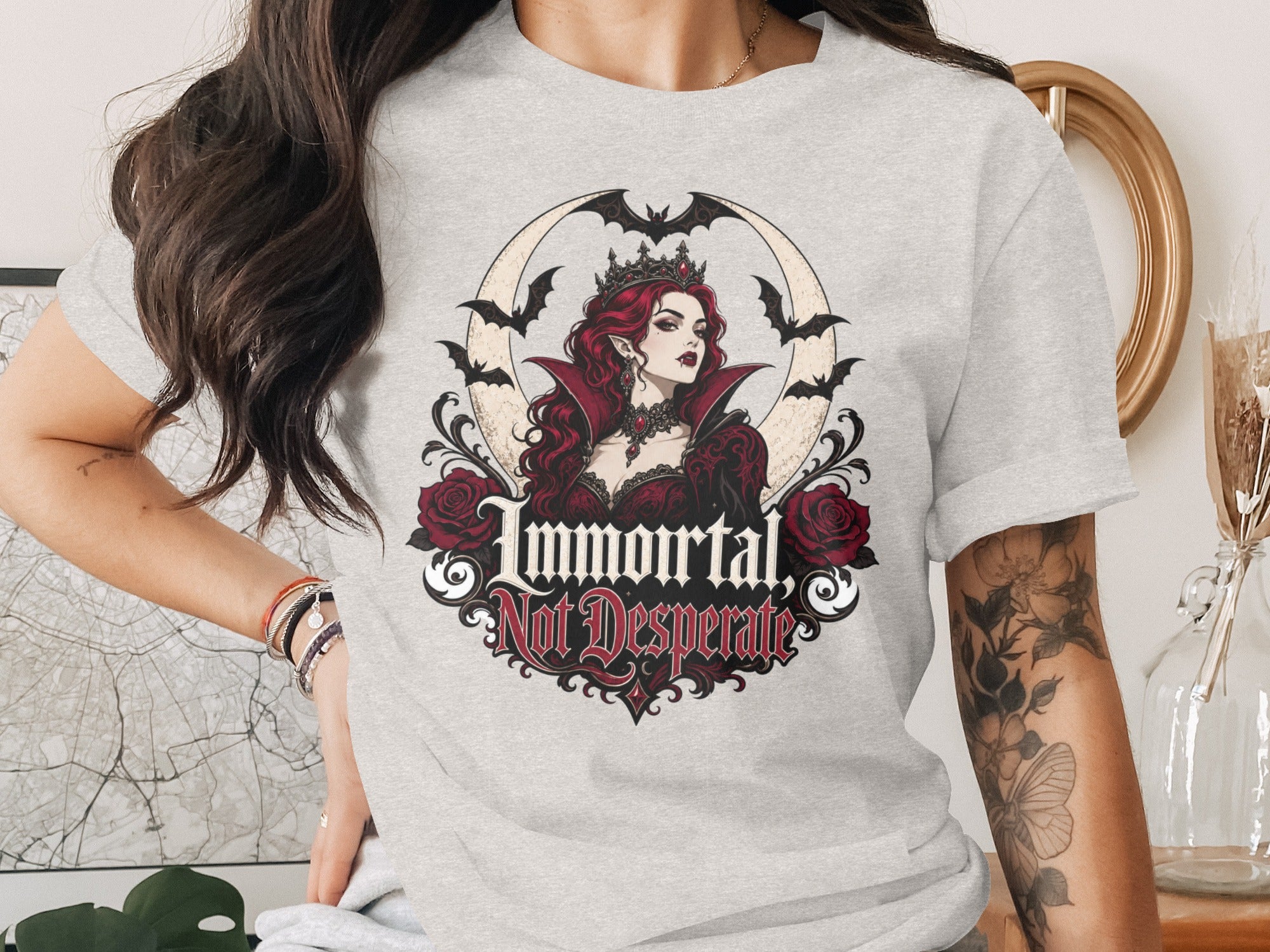 A vampire queen with red hair wears a crown and is surrounded by bats and roses.