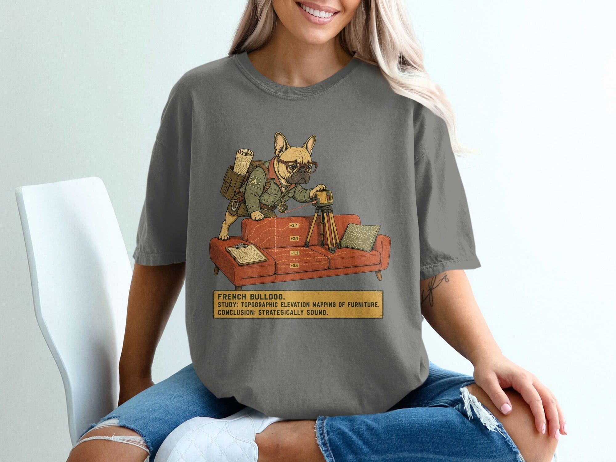 French bulldog studying furniture elevation with a surveyor's tool on a couch.