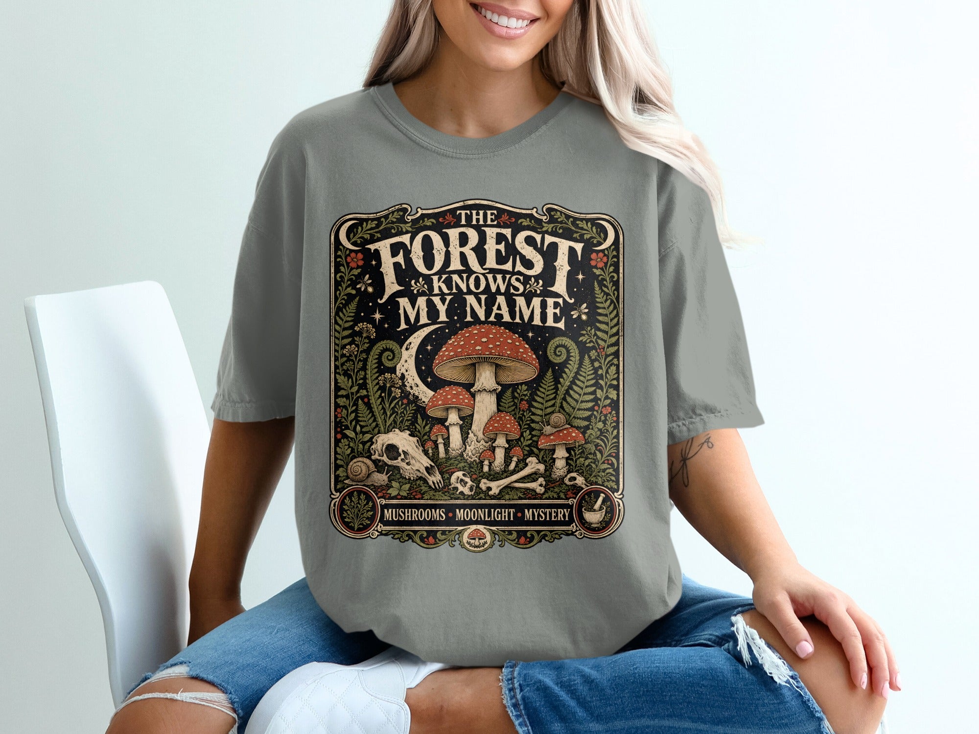 The forest knows my name graphic with mushrooms, moon, skull, and text.