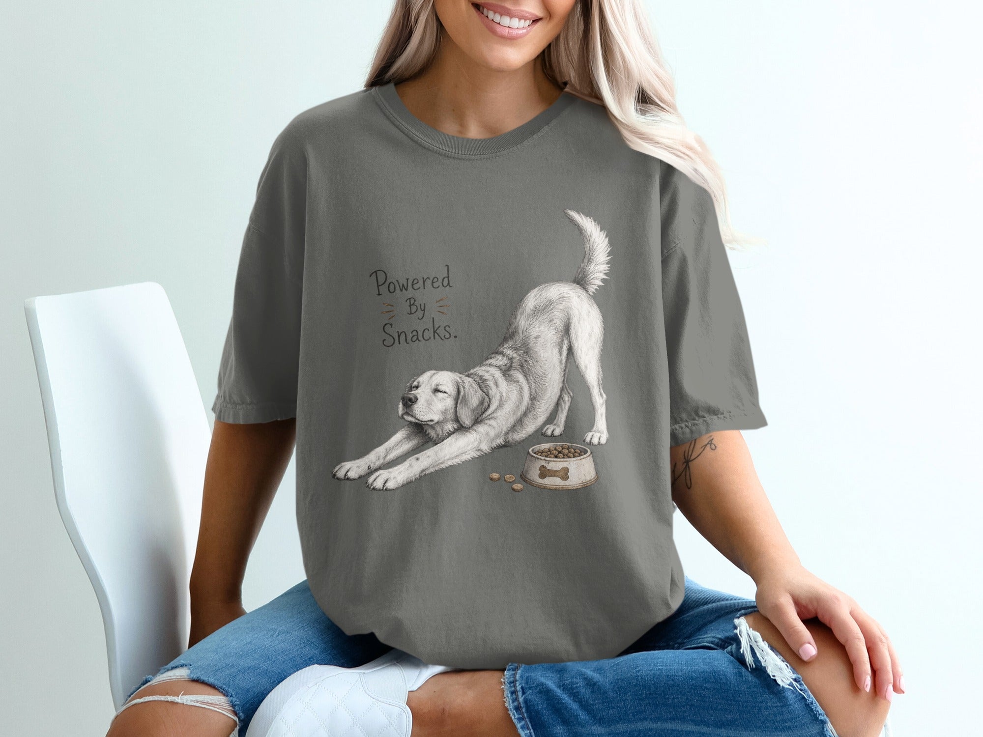 Charcoal t-shirt with a drawing of a stretching dog and the text "Powered By Snacks."