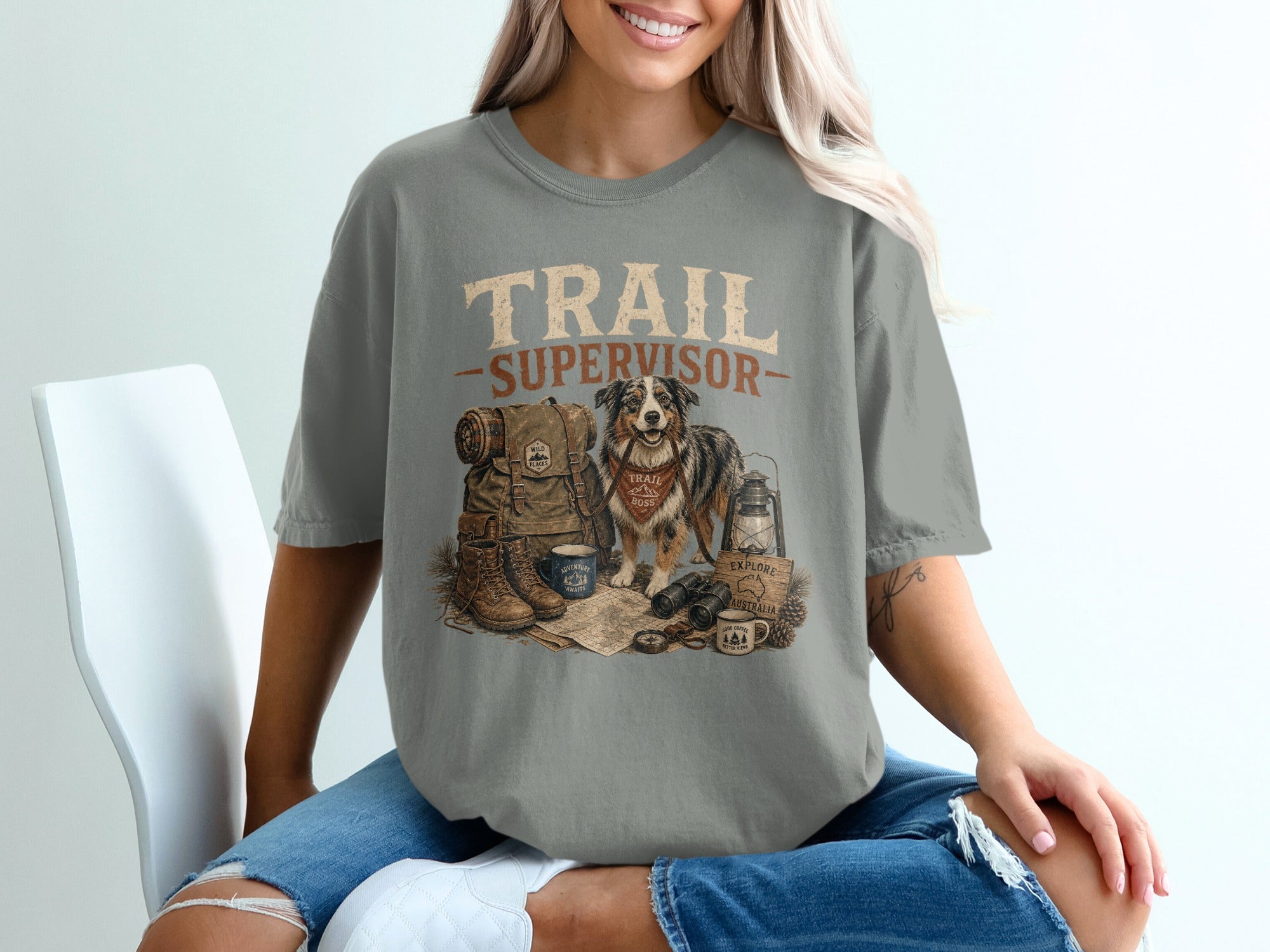 T-shirt graphic with "TRAIL SUPERVISOR" text, dog, backpack, boots, and camping gear.