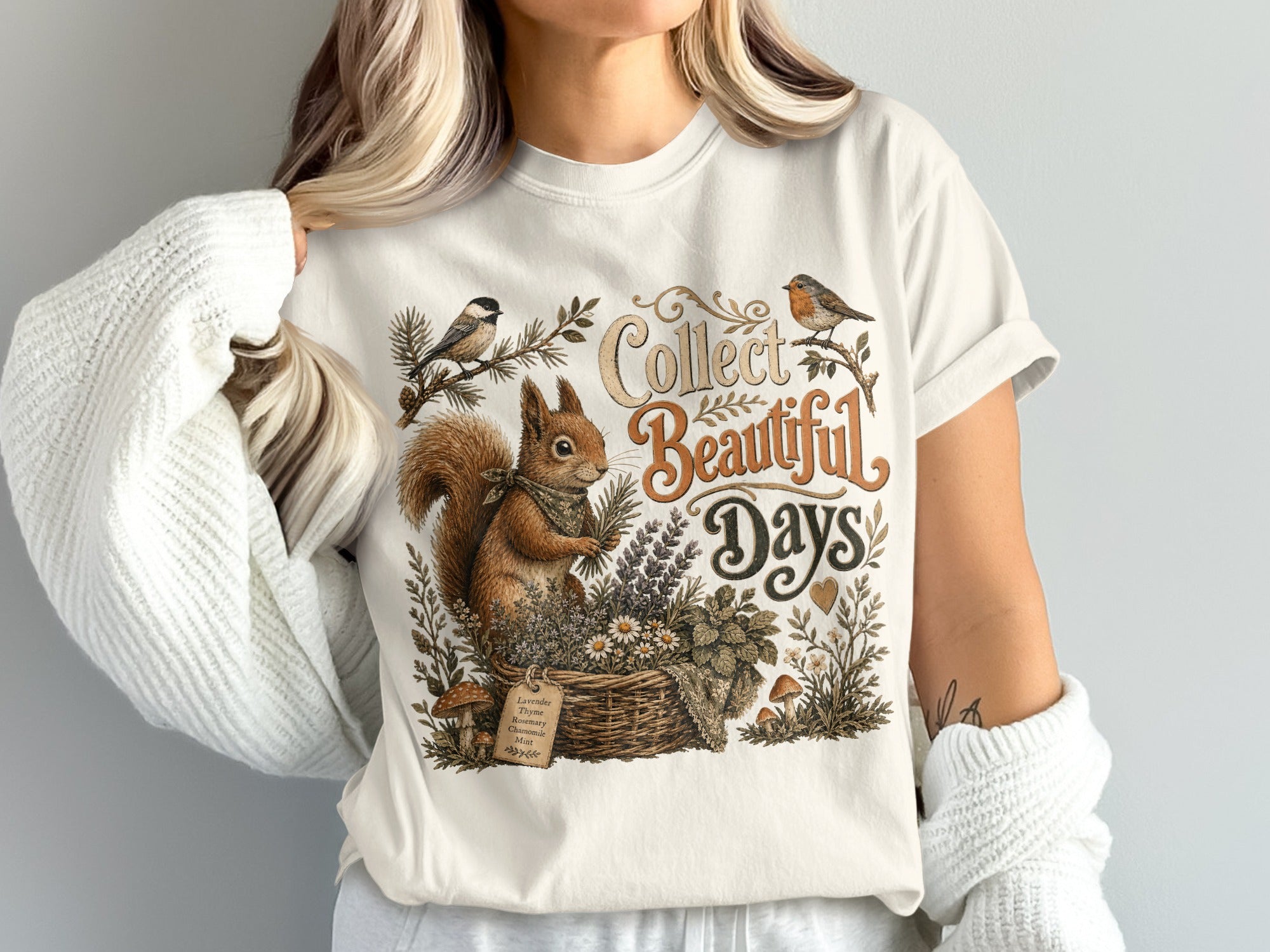 Squirrel in basket with herbs and text "Collect Beautiful Days" on shirt.