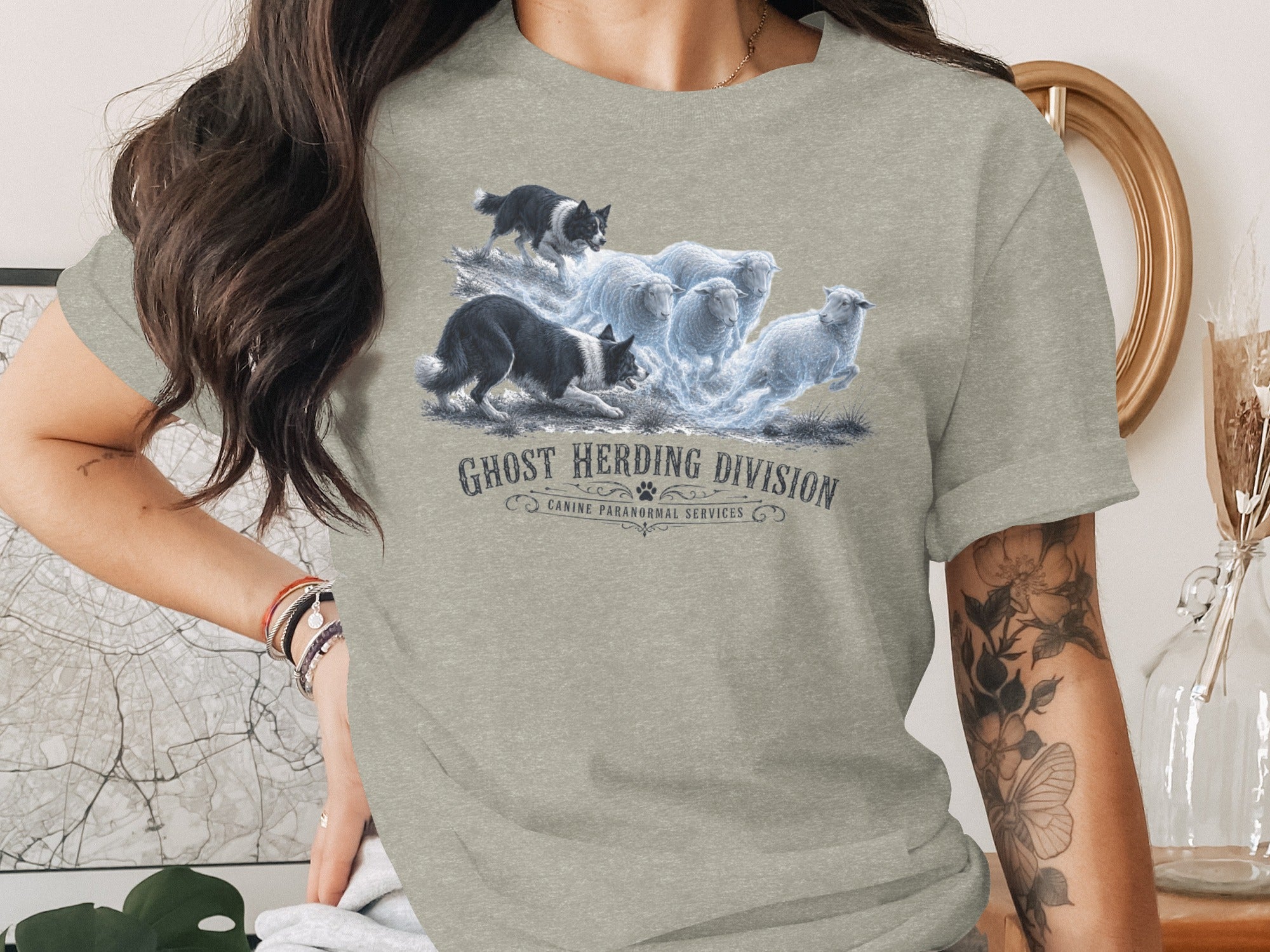 T-shirt graphic of ghostly sheep being herded by two border collies, text "Ghost Herding Division".