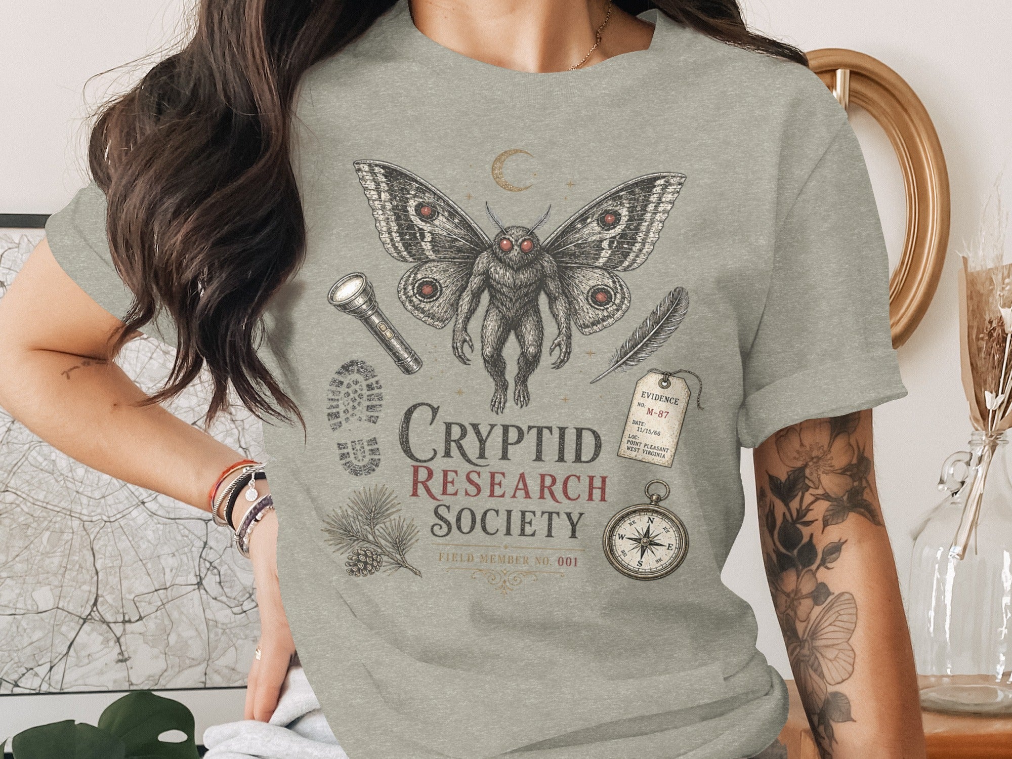 Mothman design with "Cryptid Research Society" text and vintage research illustrations.