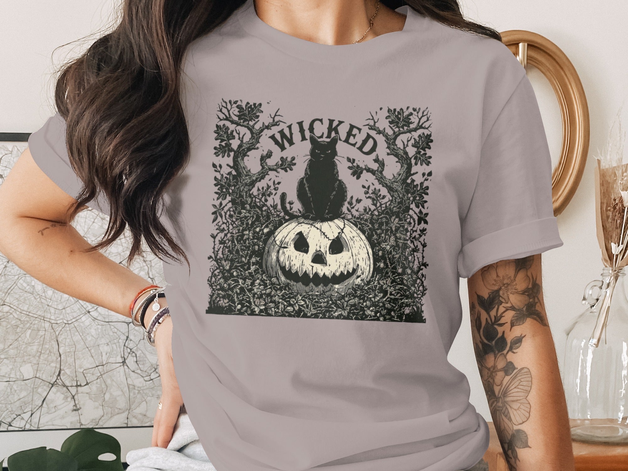 Black cat on carved pumpkin with "WICKED" text and gothic trees.