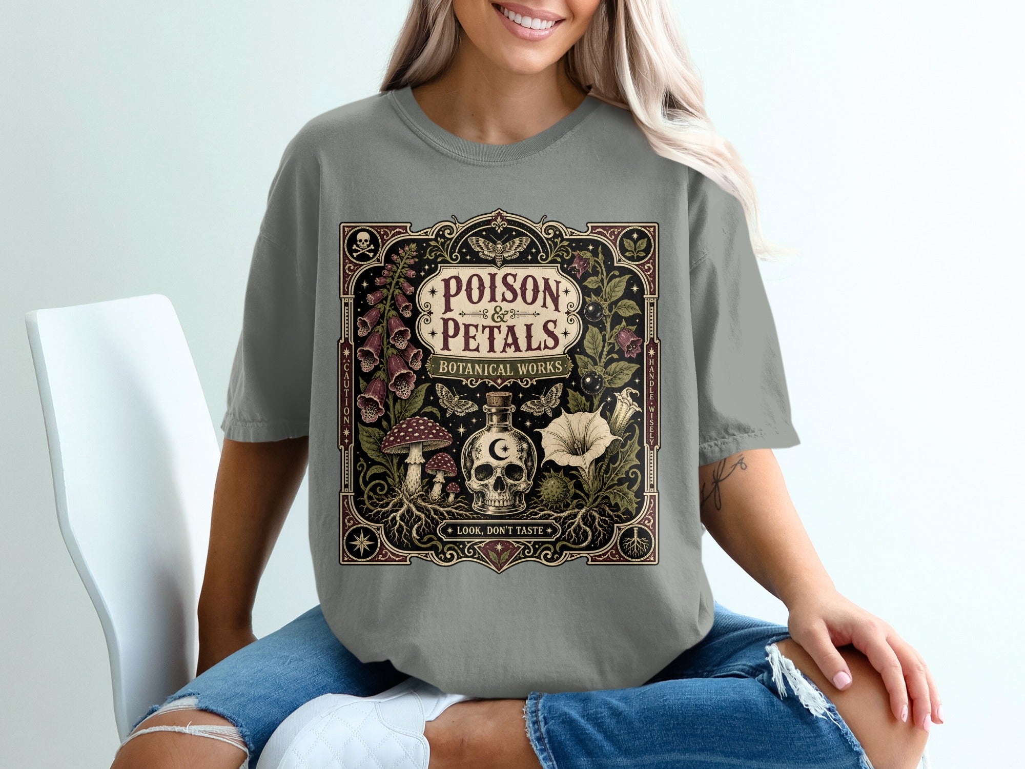 T-shirt graphic with "POISON & PETALS BOTANICAL WORKS" and skull, mushrooms, and flowers.