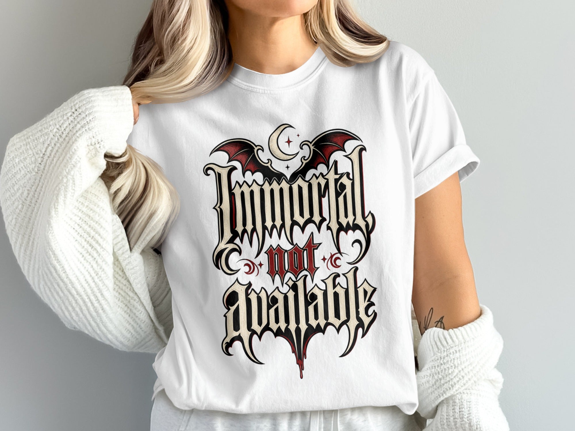 White t-shirt with gothic text that reads "Immortal not available" with bats and moon.