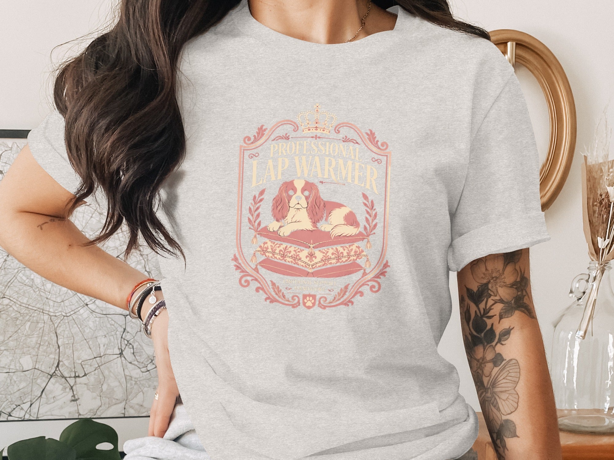 Gray t-shirt with a crest depicting a dog on pillows, text "PROFESSIONAL" and "LAP WARMER".