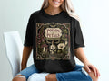Black t-shirt with "POISON PETALS BOTANICAL WORKS" and mystical botanical design.