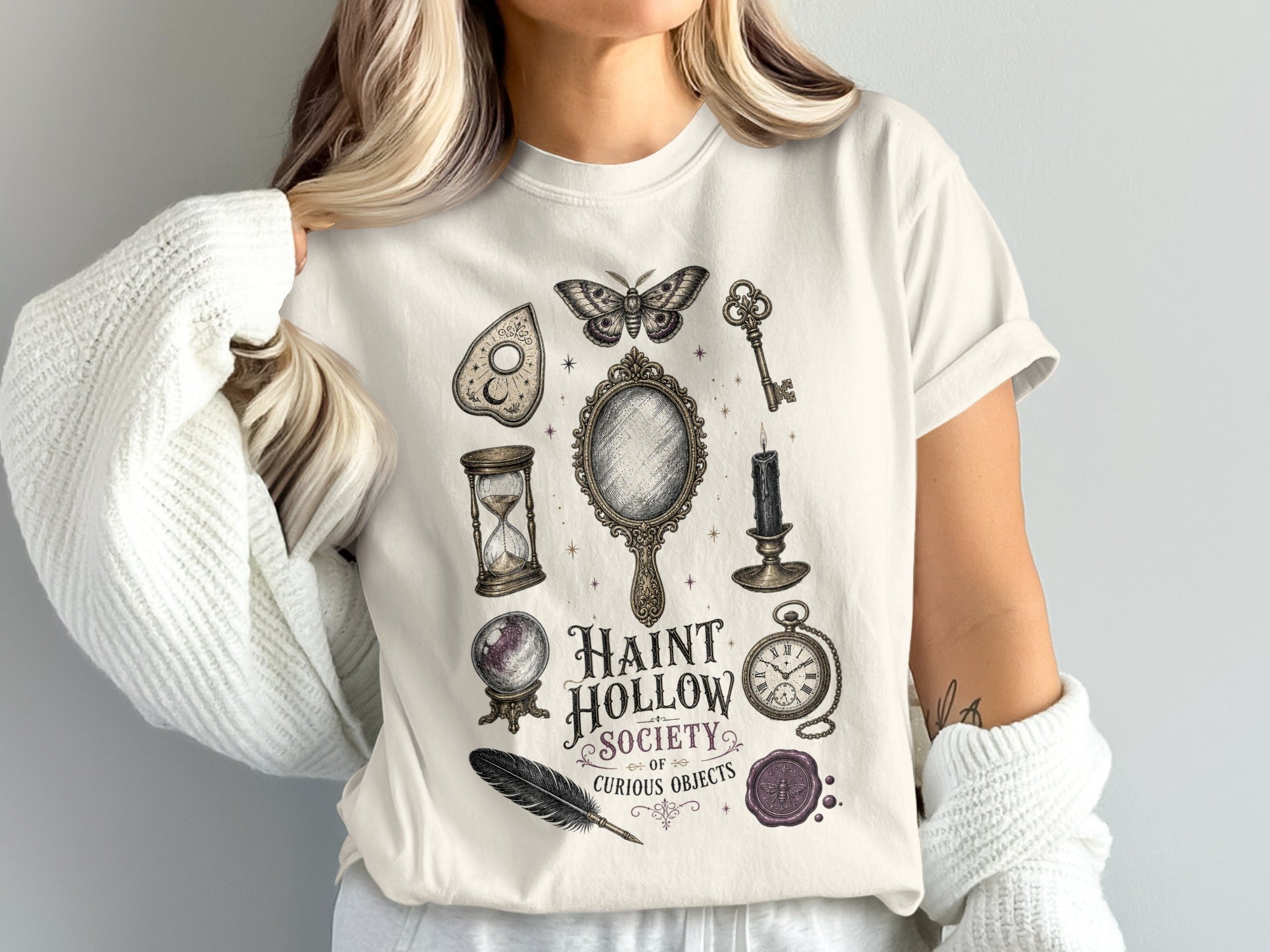 T-shirt graphic with Haunt Hollow Society text and occult objects.