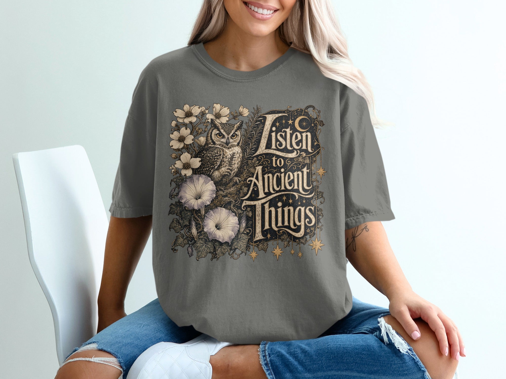 Gray t-shirt with an owl, flowers, and text "Listen to Ancient Things".