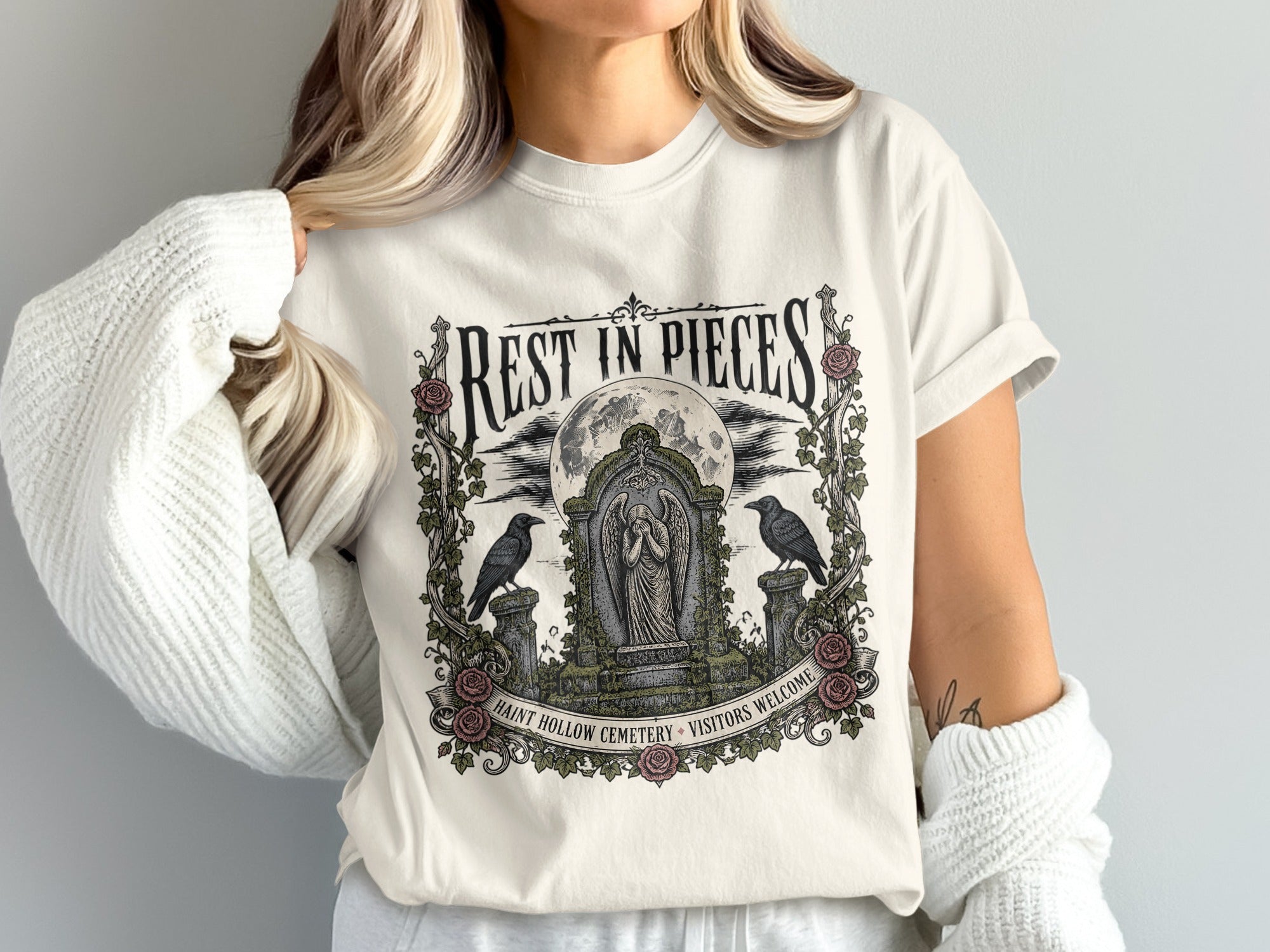Shirt with "Rest in Pieces" and cemetery graphic with a statue and crows.