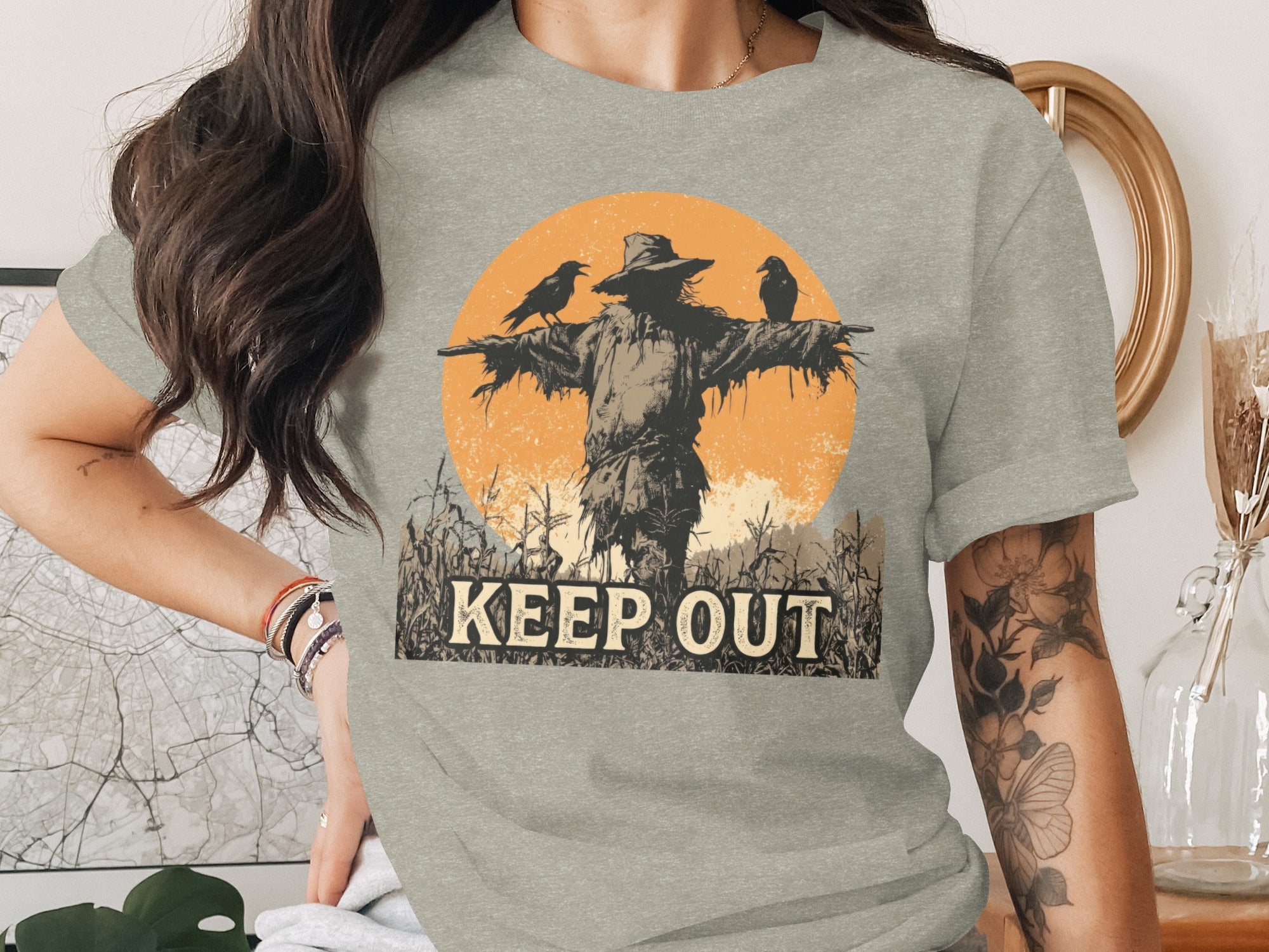 Scarecrow with crows and "KEEP OUT" text against an orange sunburst.