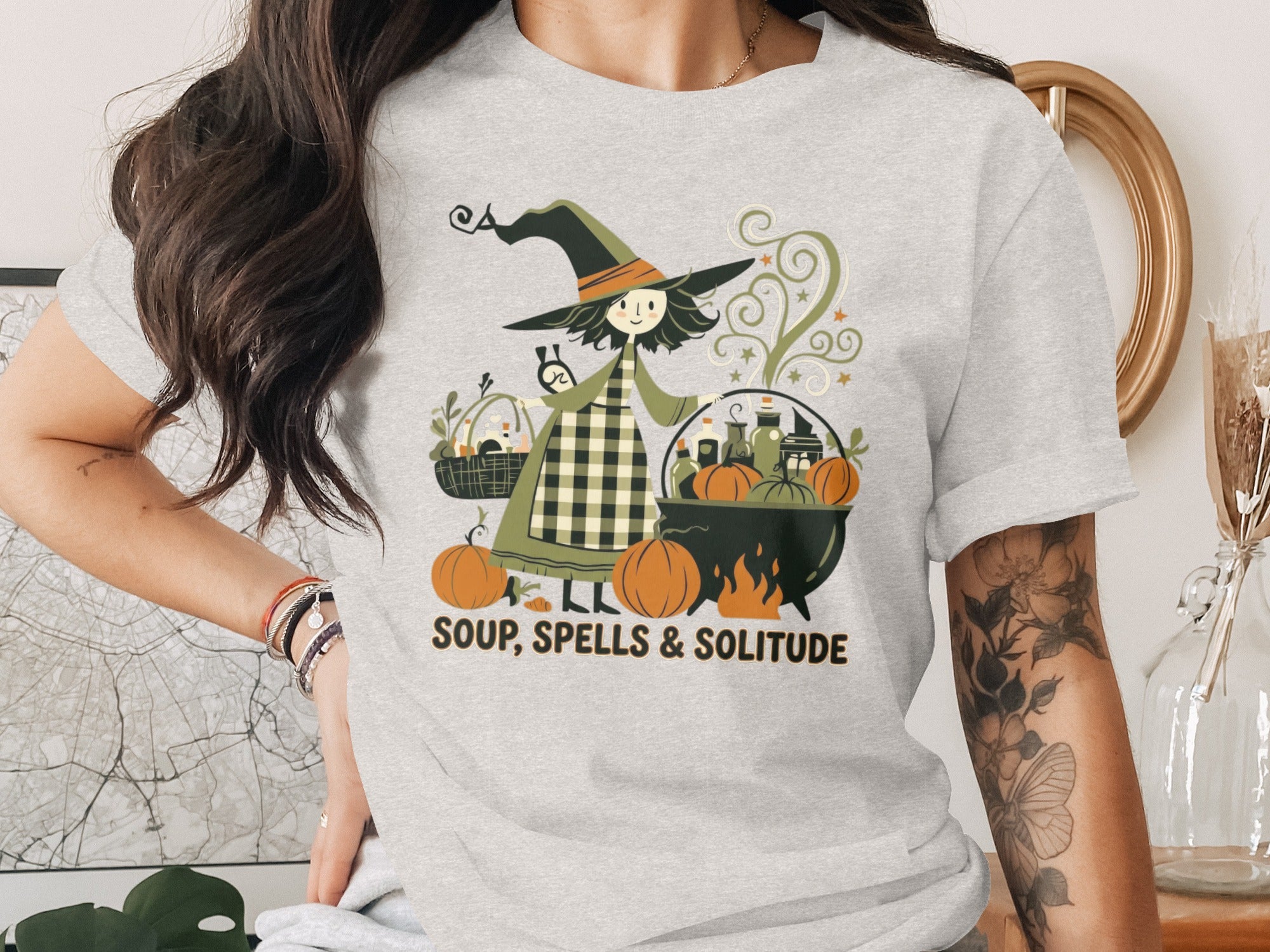 Witch with cauldron, pumpkins, and basket, text reads SOUP, SPELLS & SOLITUDE.