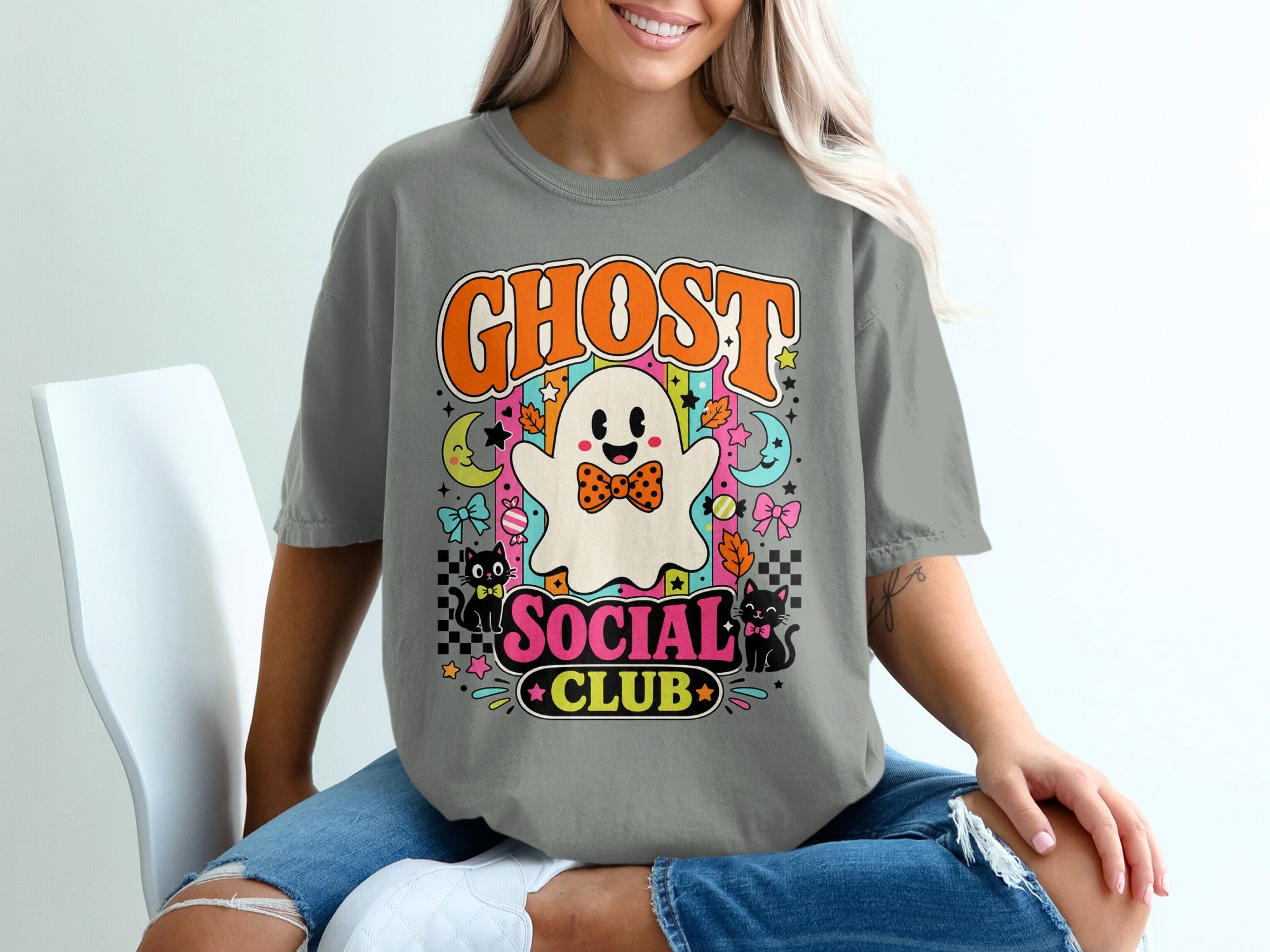 Ghost Social Club graphic with a ghost, cats, moons, and stars on a gray t-shirt.