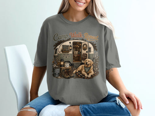 Graphic on t-shirt: "Camp. Walk. Repeat." with a trailer, dog, and camping gear.
