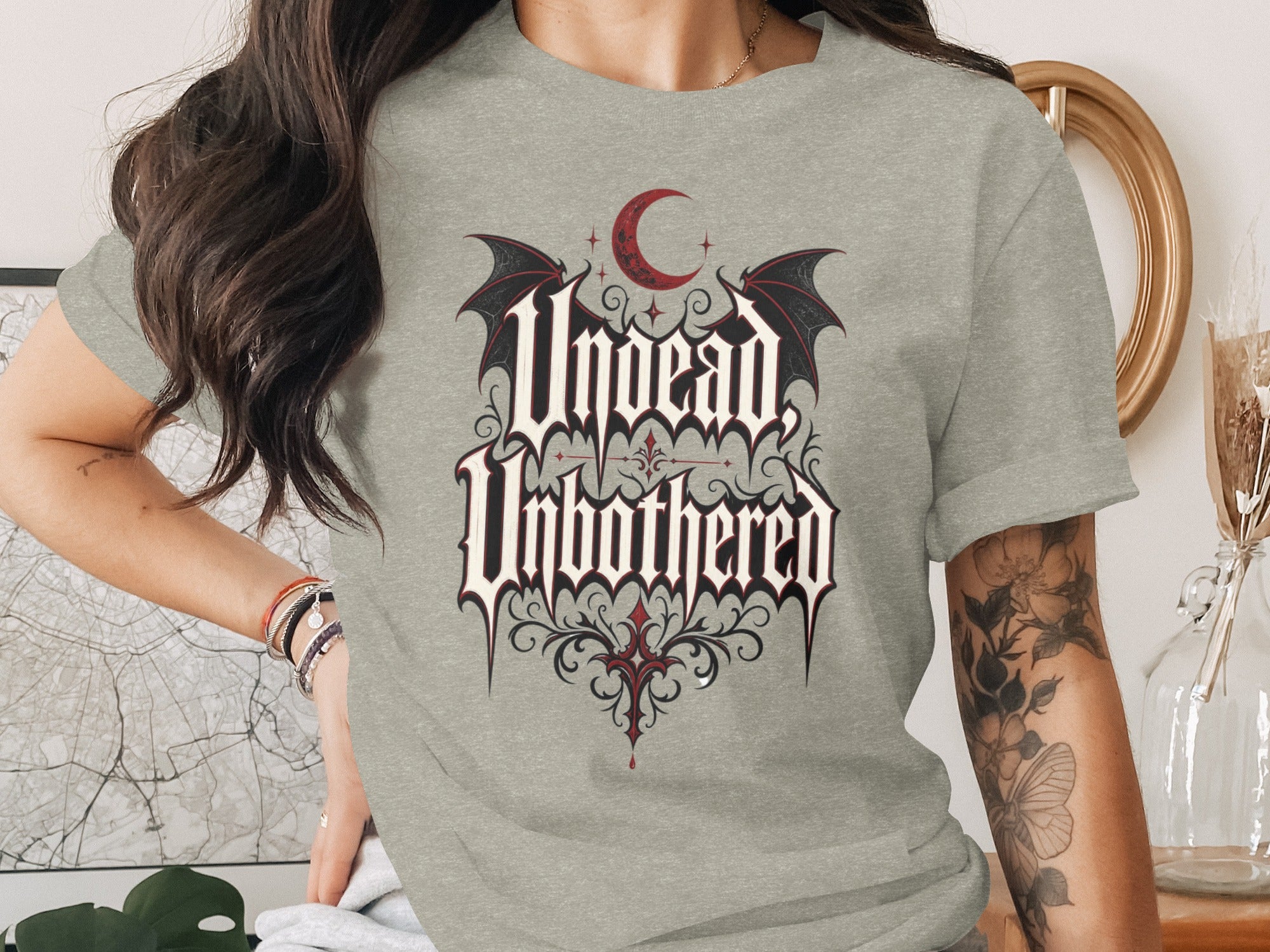 Grey t-shirt with "Undead Unbothered" text, bat wings, and red crescent moon.