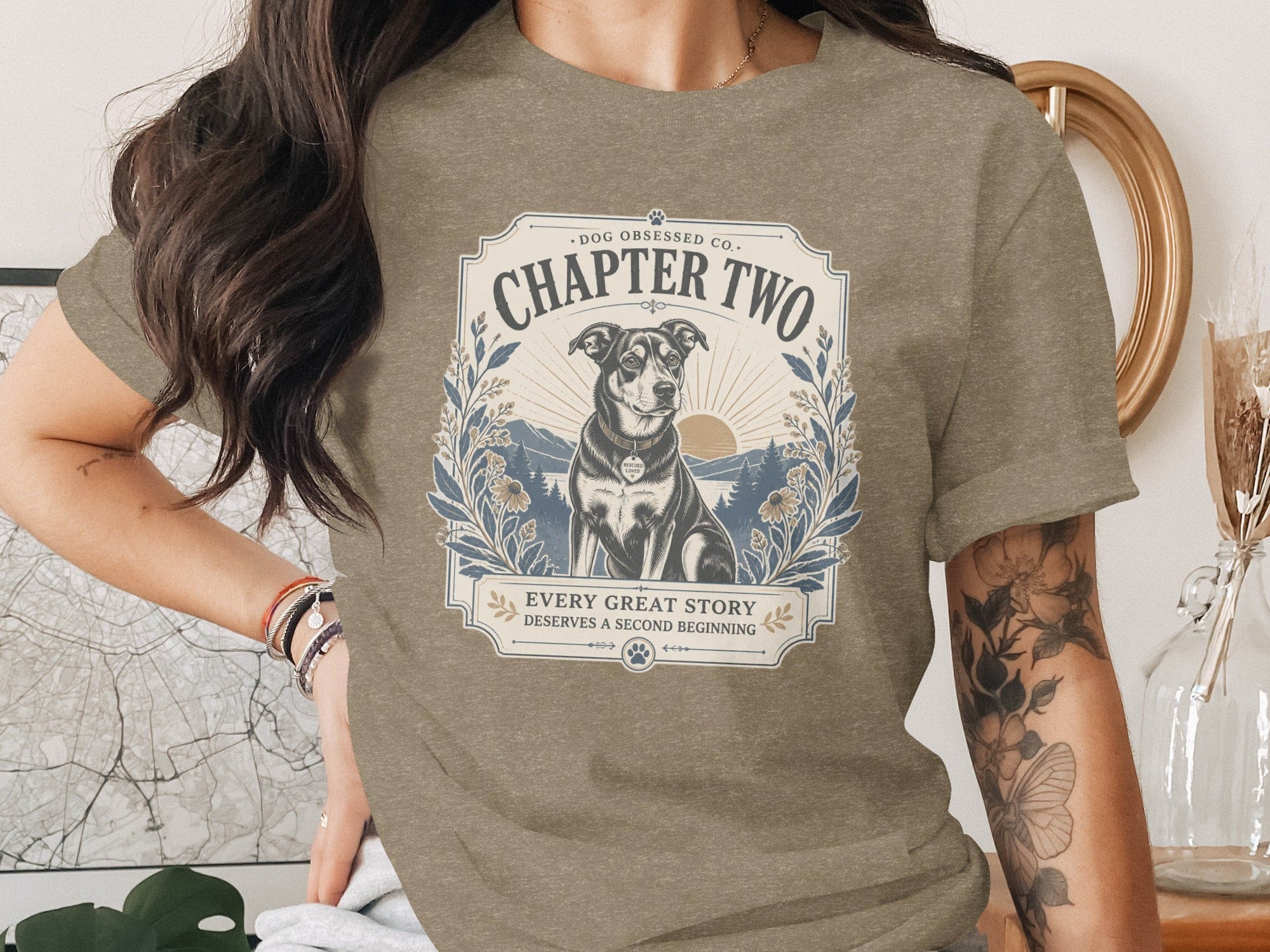 T-shirt graphic with a dog, sun, mountains, and text "Chapter Two" and "Every Great Story Deserves A Second Beginning."