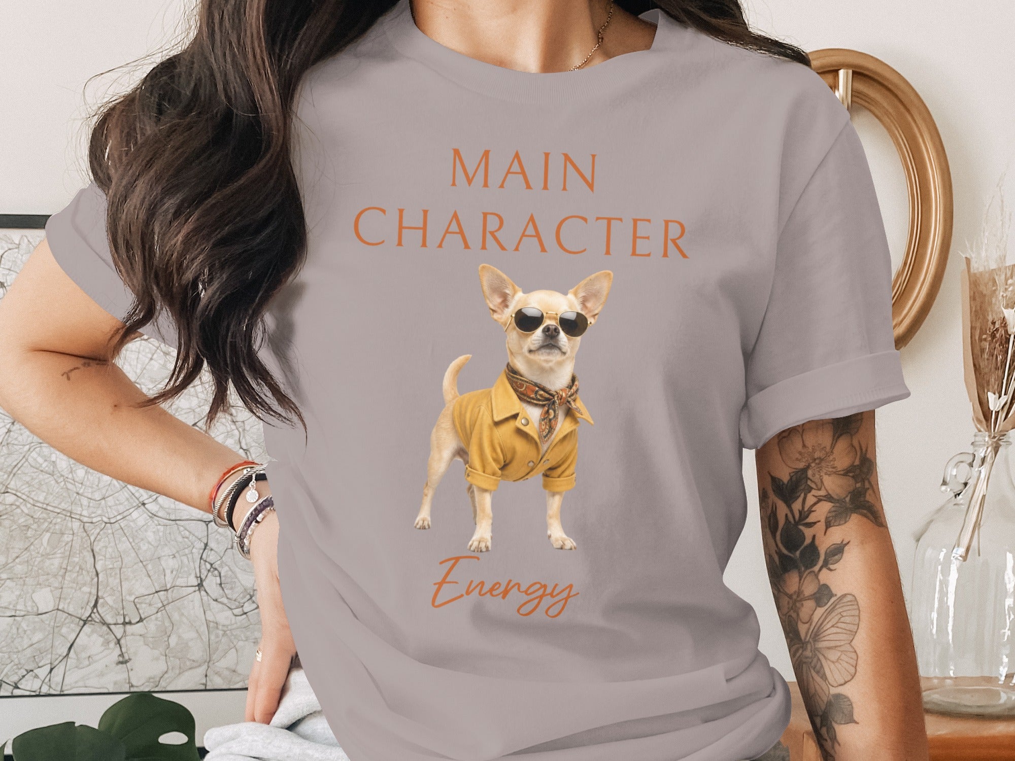 Grey t-shirt with "MAIN CHARACTER Energy" and a chihuahua wearing sunglasses and a yellow shirt.