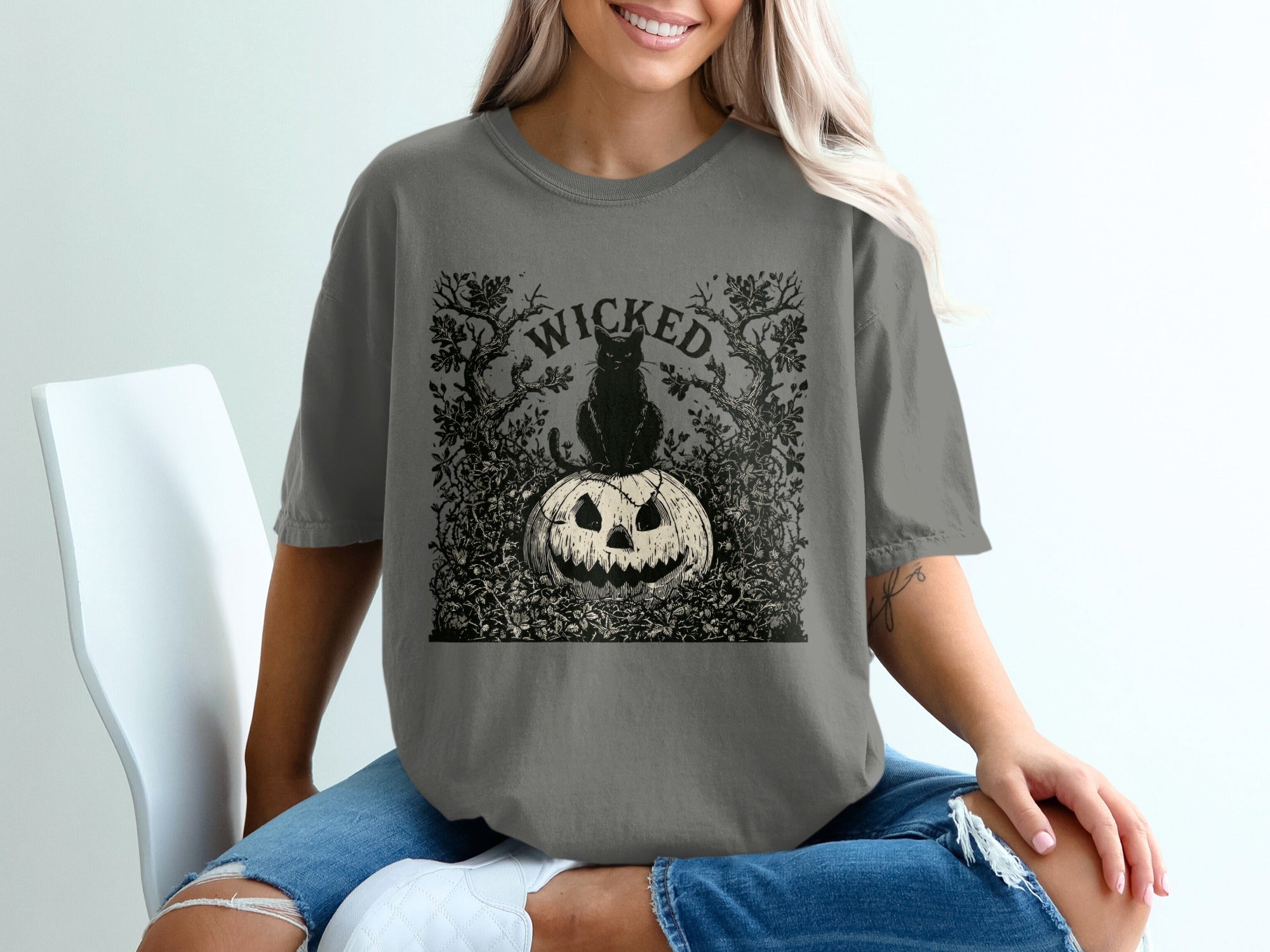 "Wicked" text graphic featuring a black cat on a carved pumpkin with spooky trees.