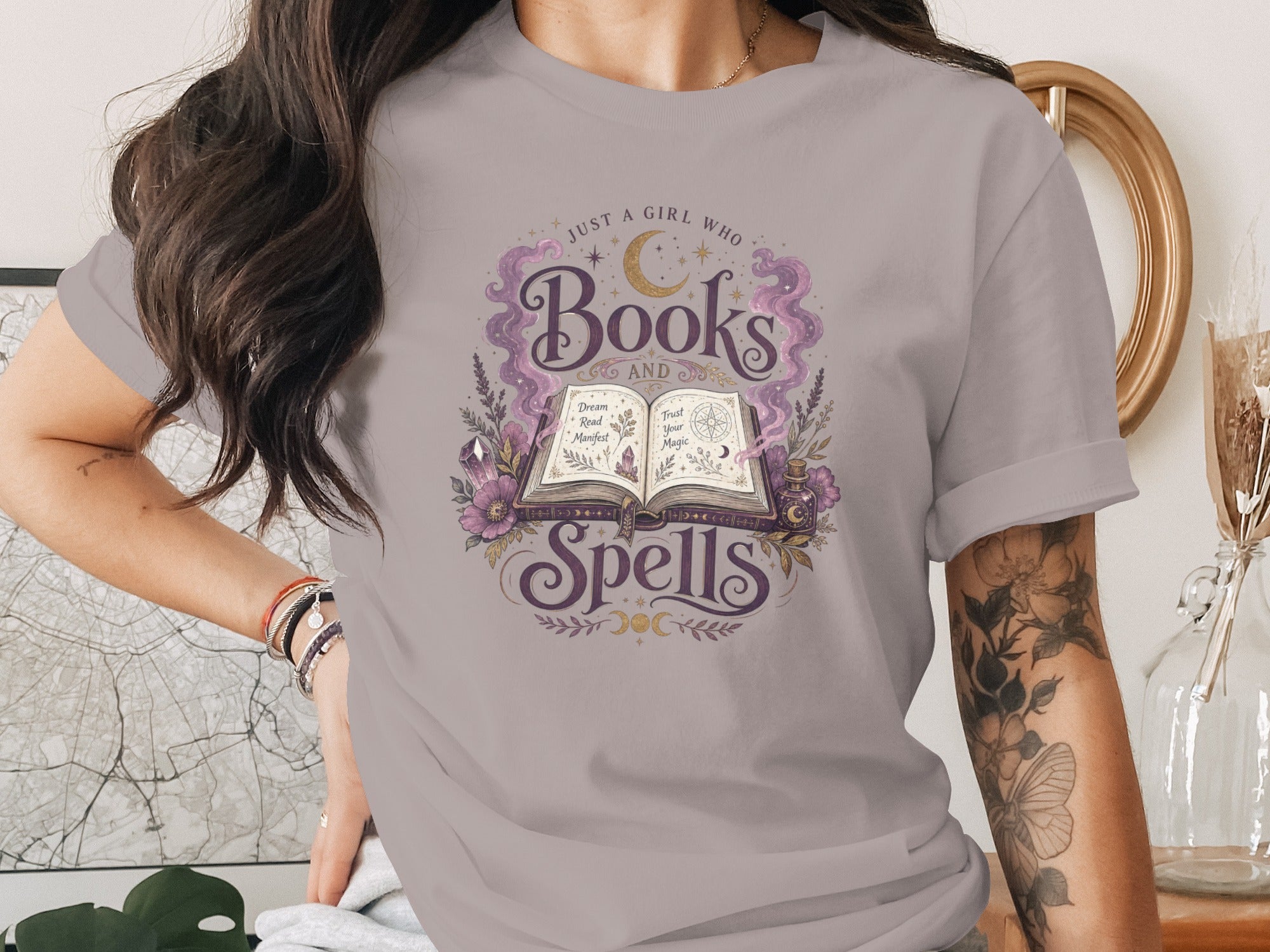 Grey t-shirt featuring an open book with "Books and Spells" text and celestial design.