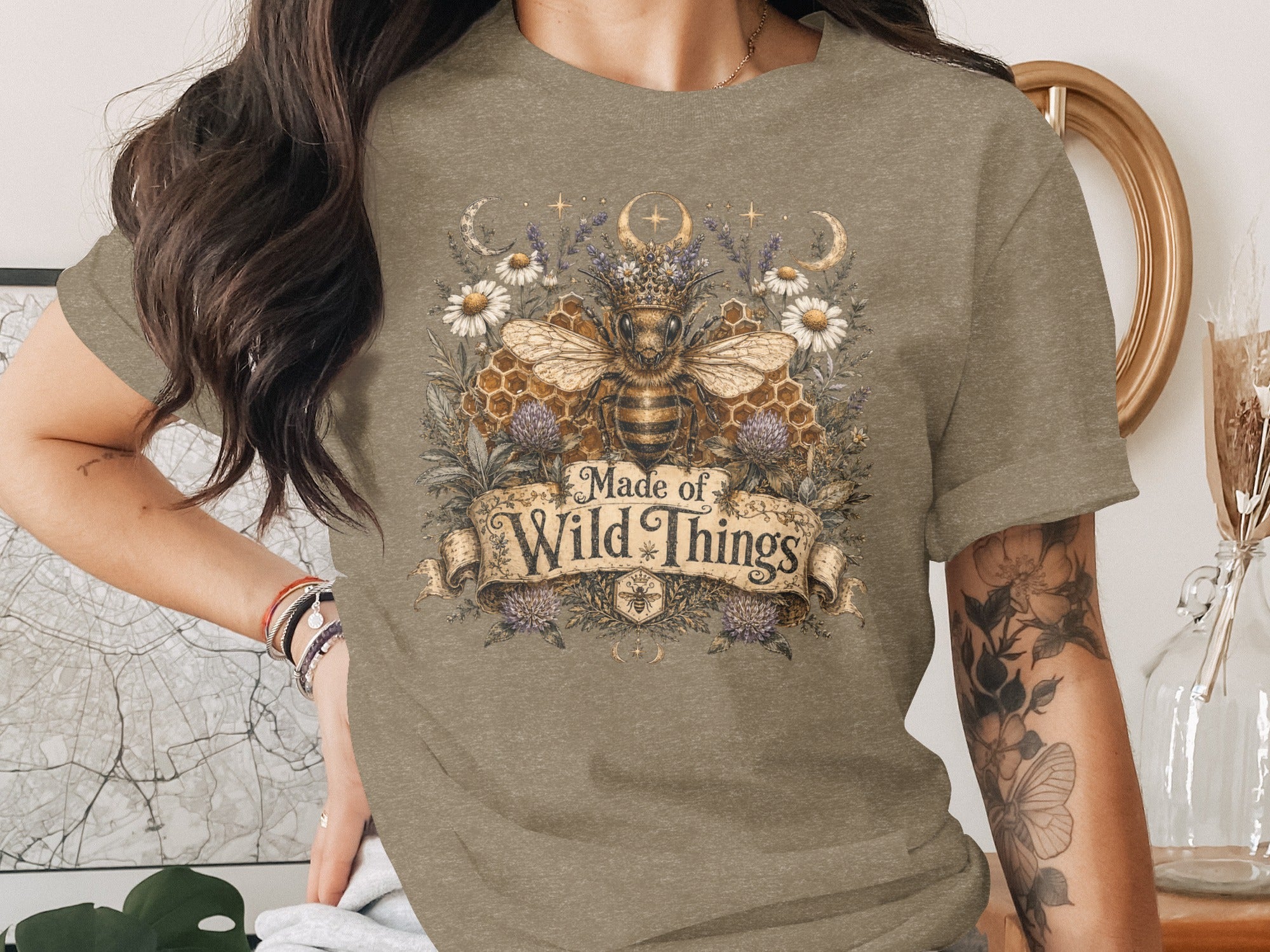 T-shirt featuring a bee crowned with flowers and crescent moons, text "Made of Wild Things".