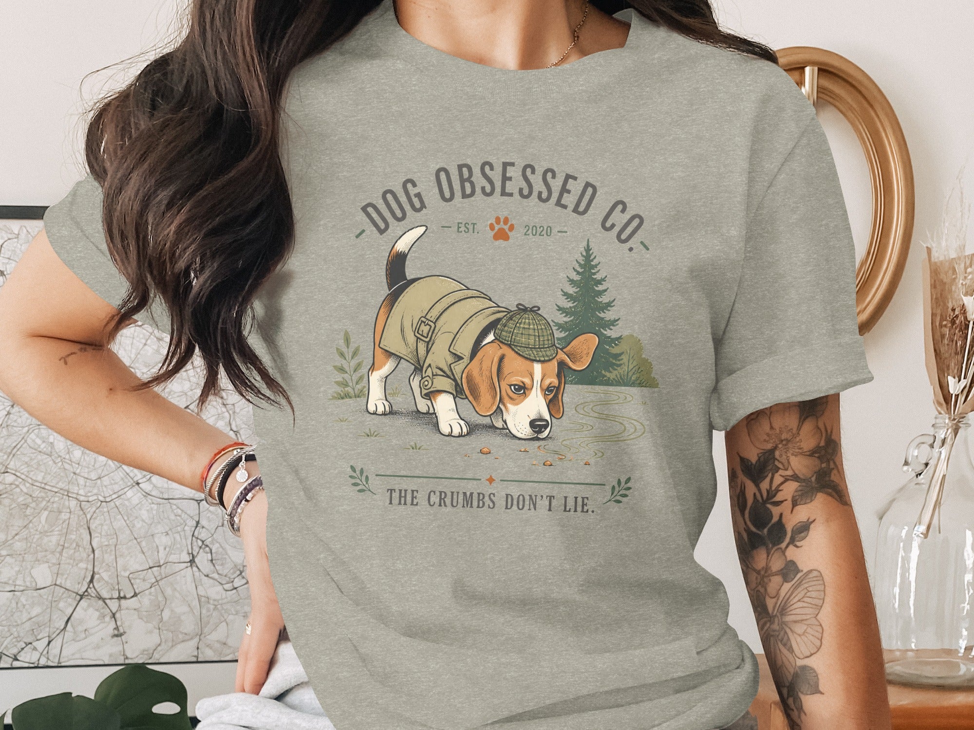 Beagle wearing a hat and coat searches for crumbs, with text "DOG OBSESSED CO." and "THE CRUMBS DON'T LIE."