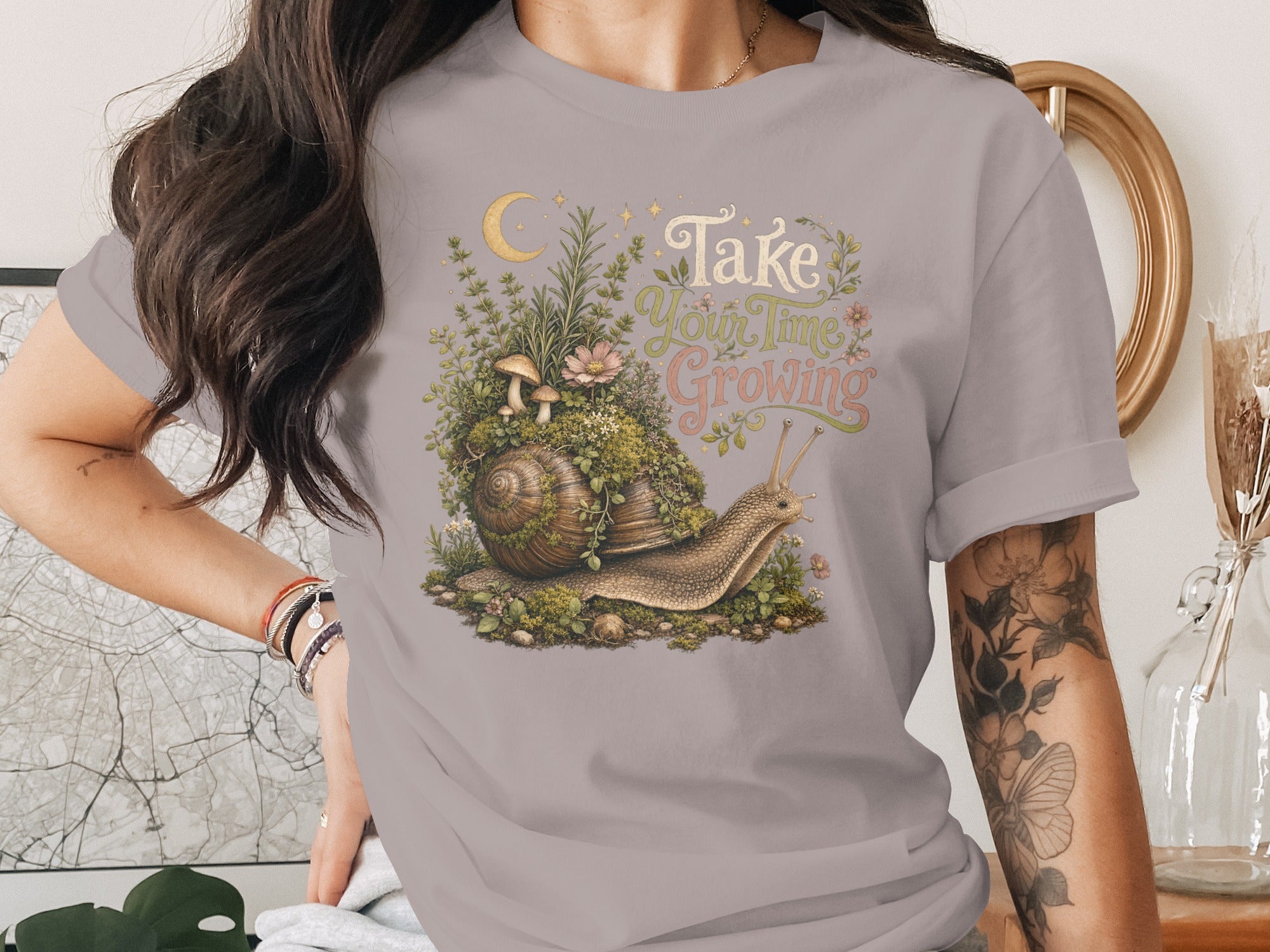 Snail with mossy shell and "Take Your Time Growing" text on a gray t-shirt.