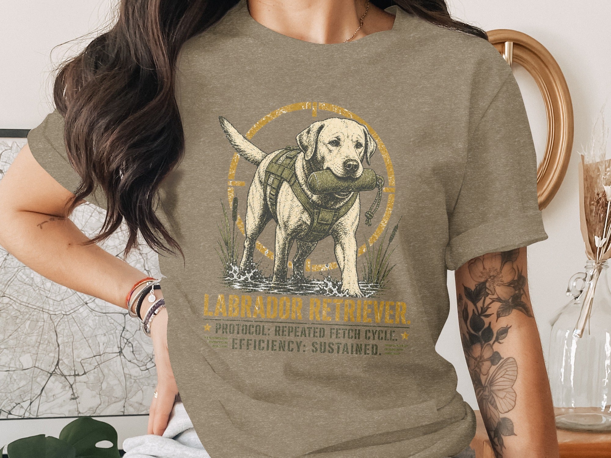Labrador Retriever tee with dog in water holding retrieve dummy.