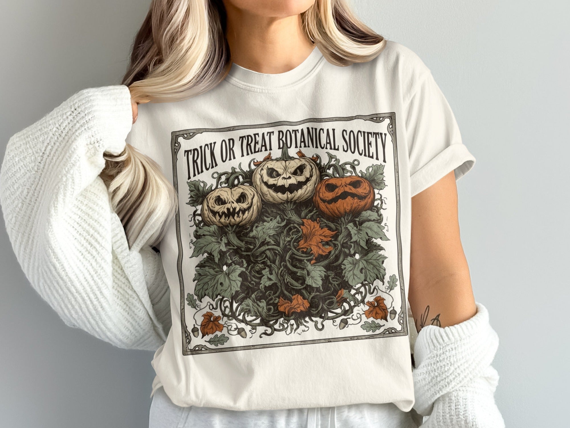 Cream t-shirt with "TRICK OR TREAT BOTANICAL SOCIETY" and three carved pumpkins.