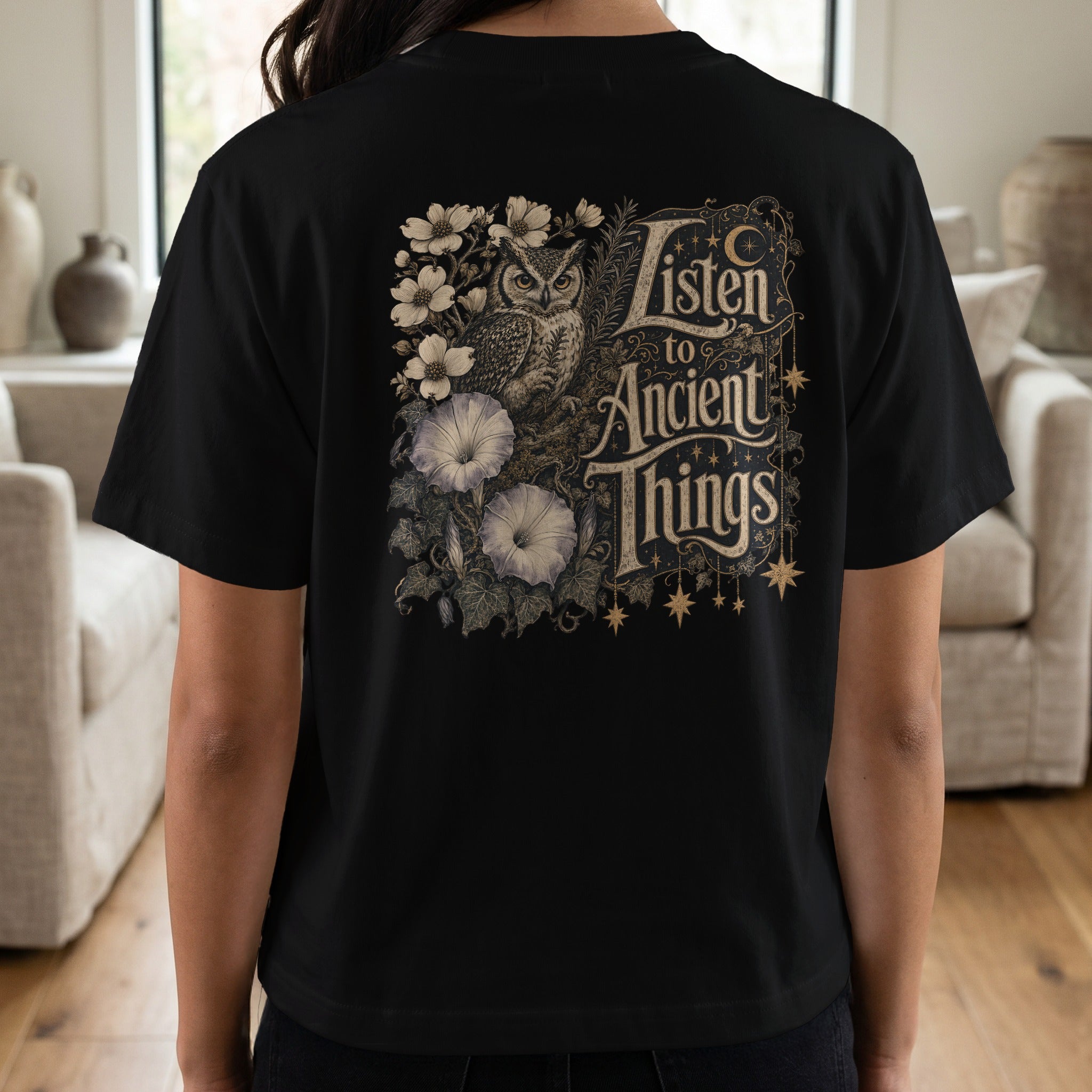 Black t-shirt with owl, flowers, and text "Listen to Ancient Things".