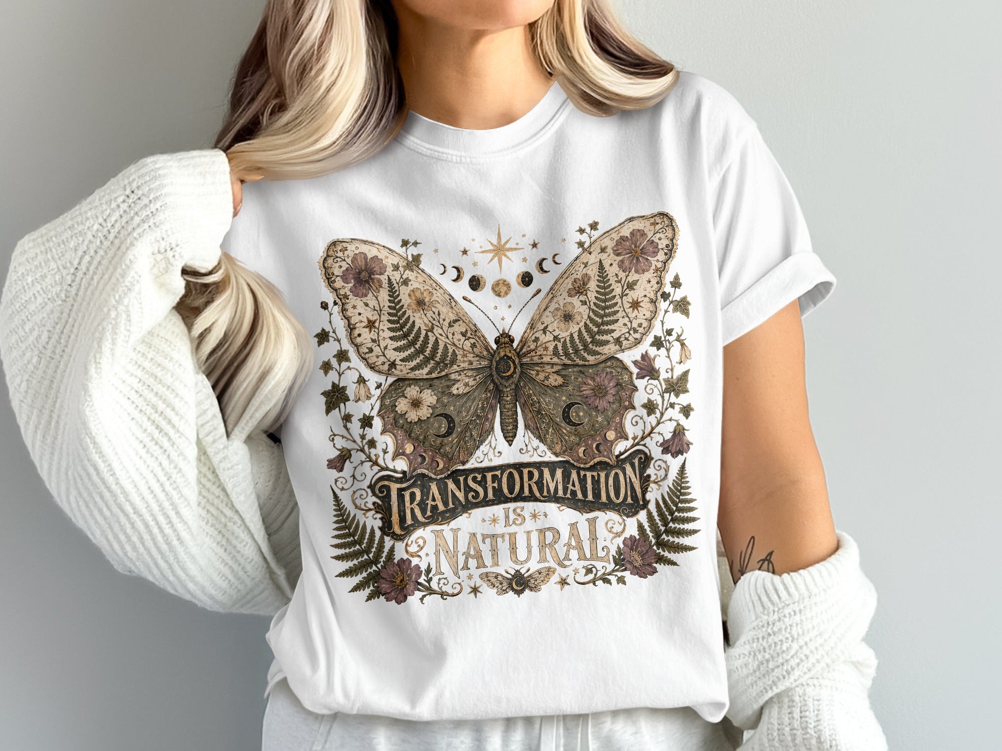 White t-shirt with a vintage butterfly graphic and text "Transformation is Natural".