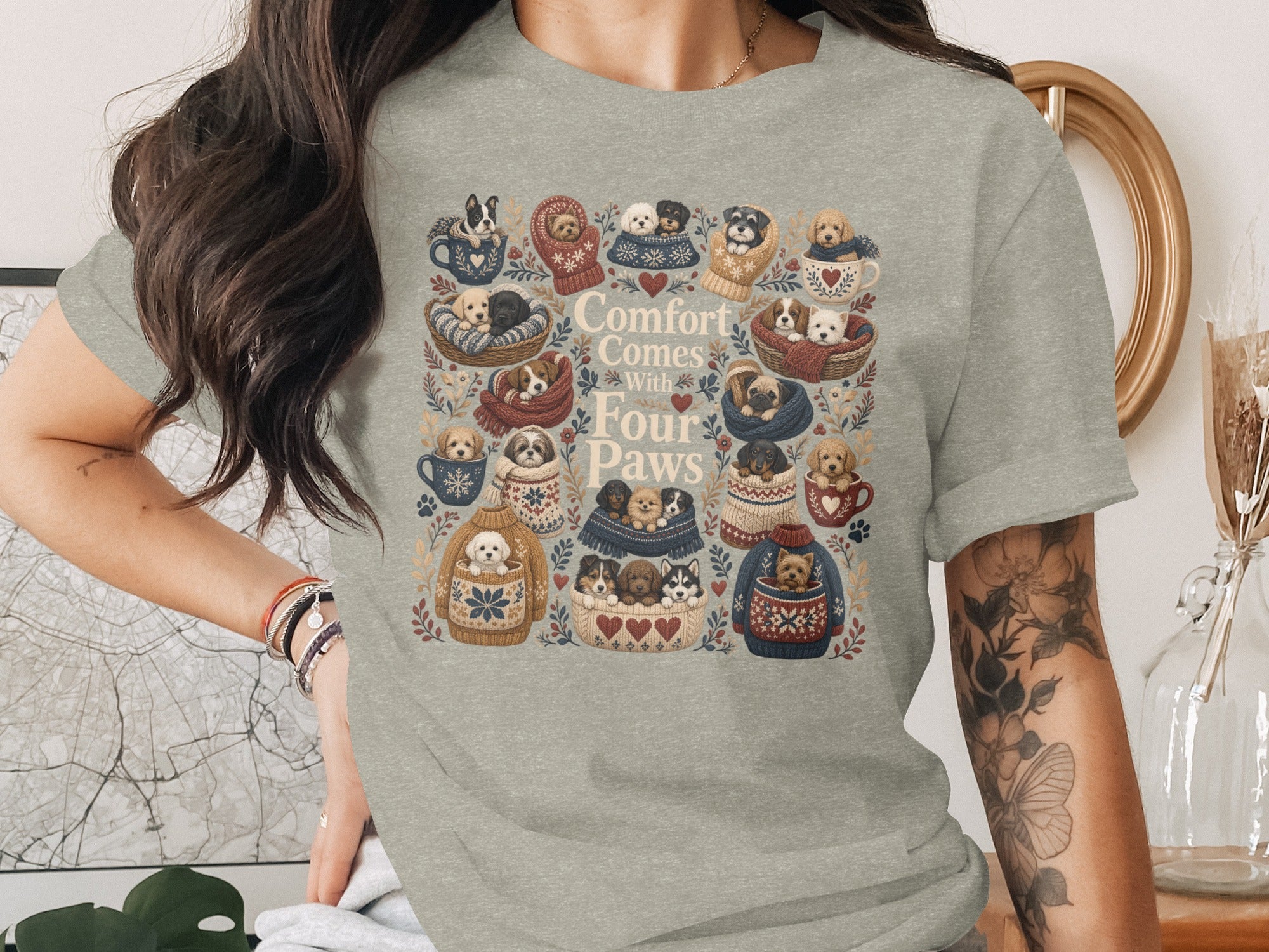 T-shirt with illustration of puppies in sweaters and cups, reading "Comfort Comes With Four Paws".