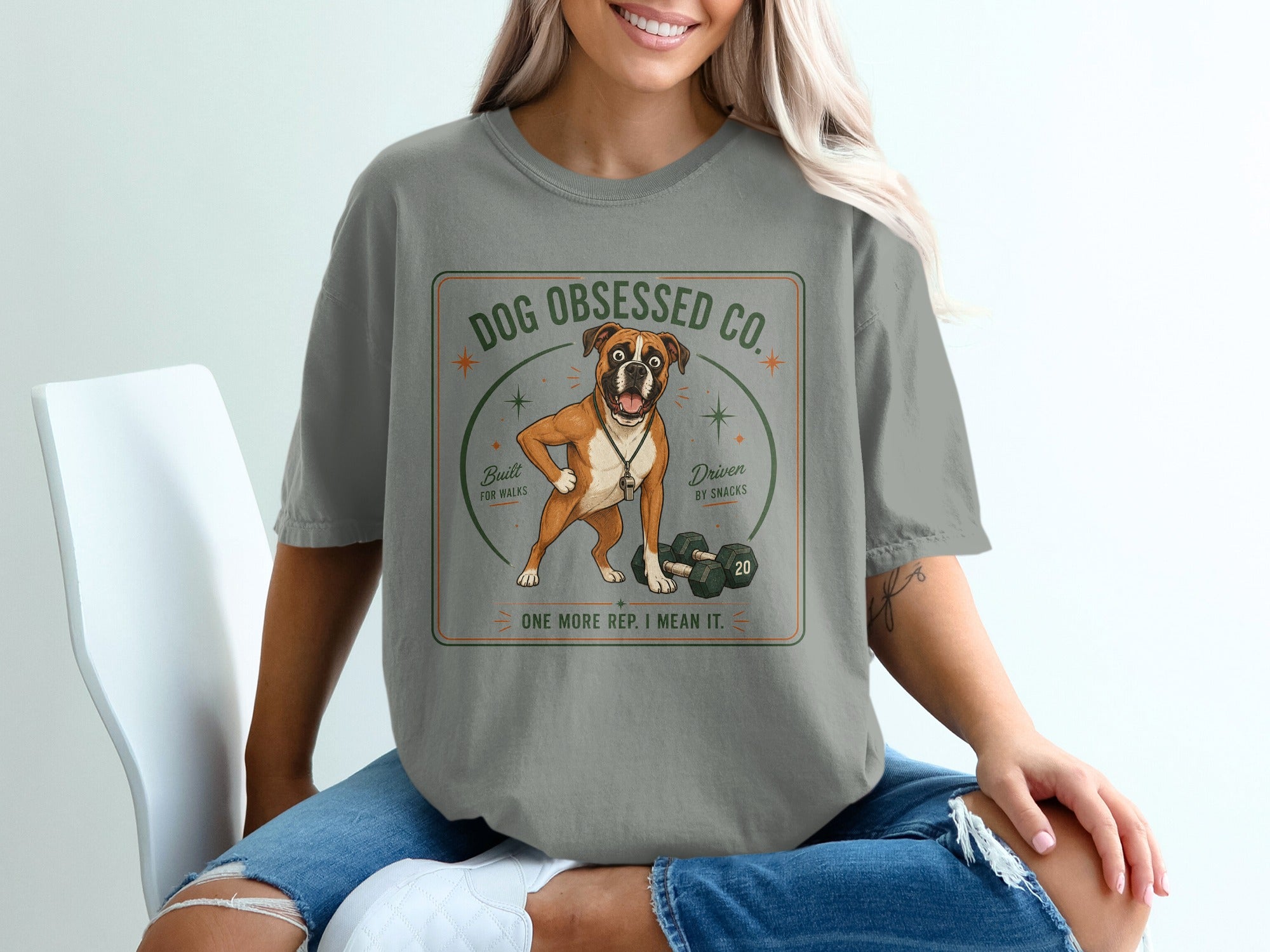 T-shirt graphic with boxer dog, dumbbells, and text "Dog Obsessed Co."