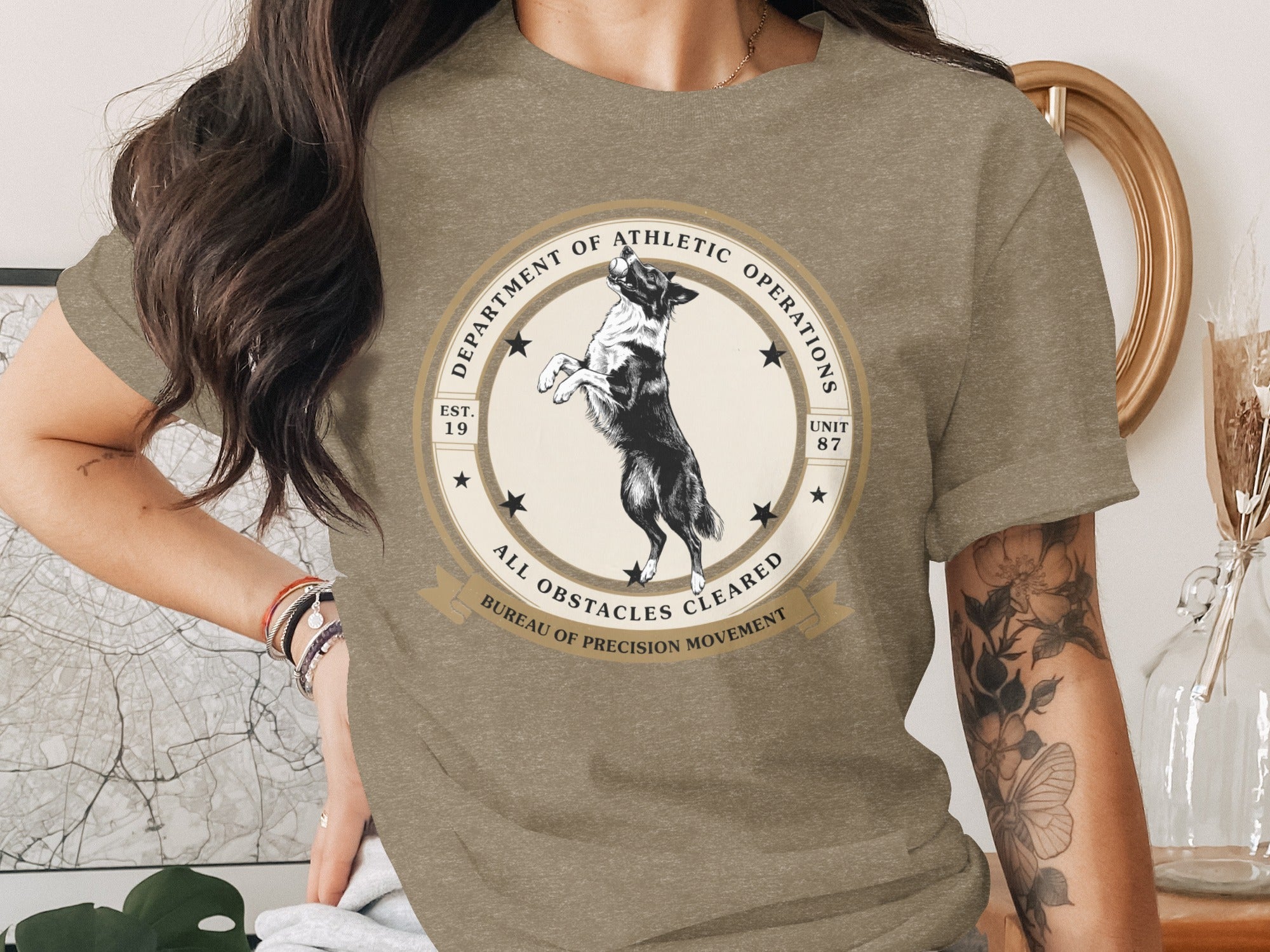 T-shirt with a black and white dog design and "Department of Athletic Operations" text.
