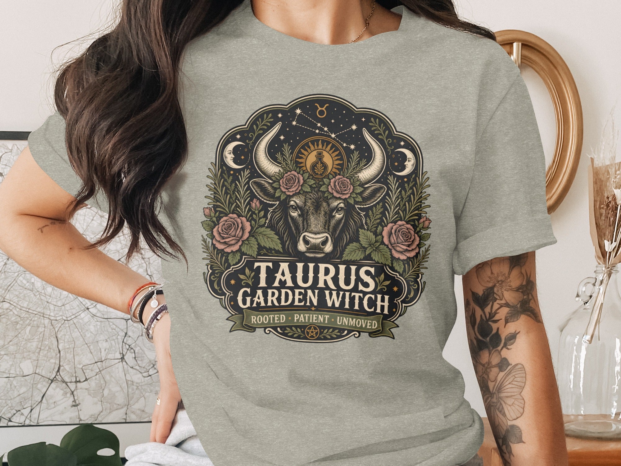 Taurus Garden Witch graphic with bull, roses, moons, and stars on a gray t-shirt.