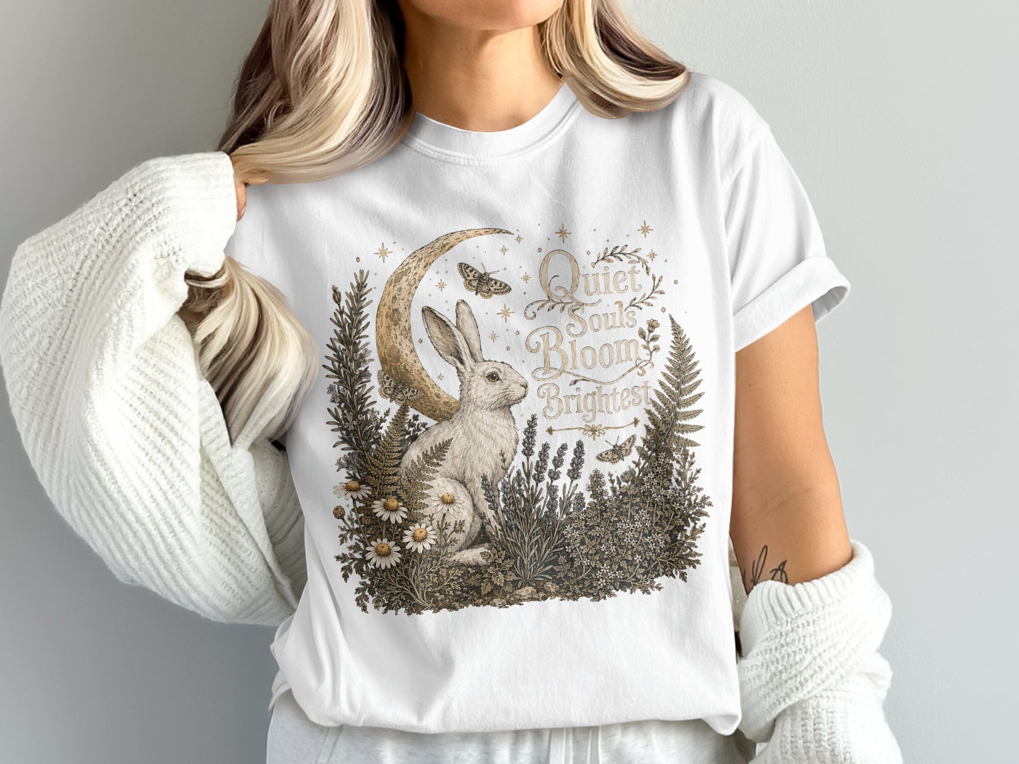White t-shirt graphic of a rabbit by a crescent moon with text "Quiet Souls Bloom Brightest".