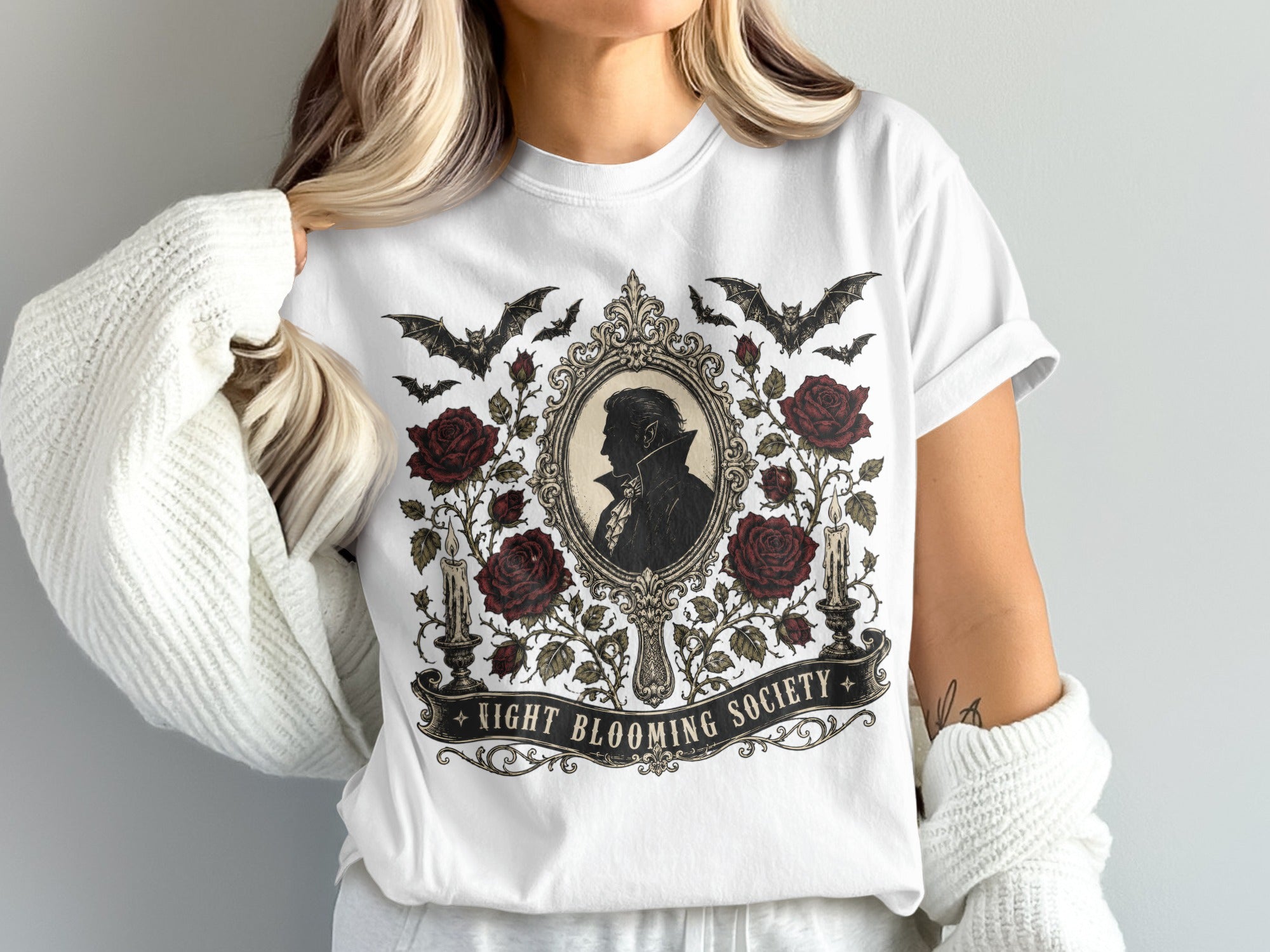 White t-shirt with "Night Blooming Society" text and vampire silhouette within ornate frame.