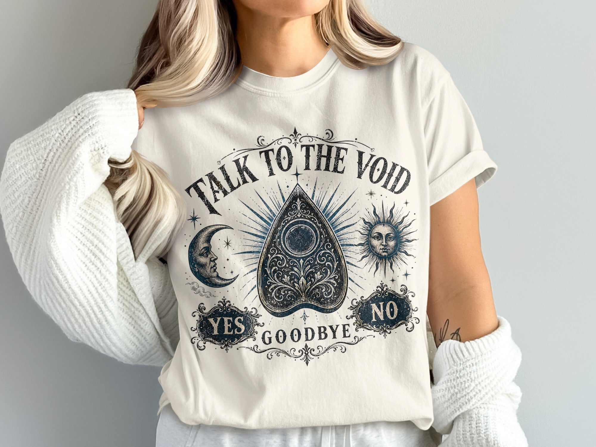 White t-shirt with "Talk to the Void" Ouija board design, moon, sun, yes, goodbye, and no.
