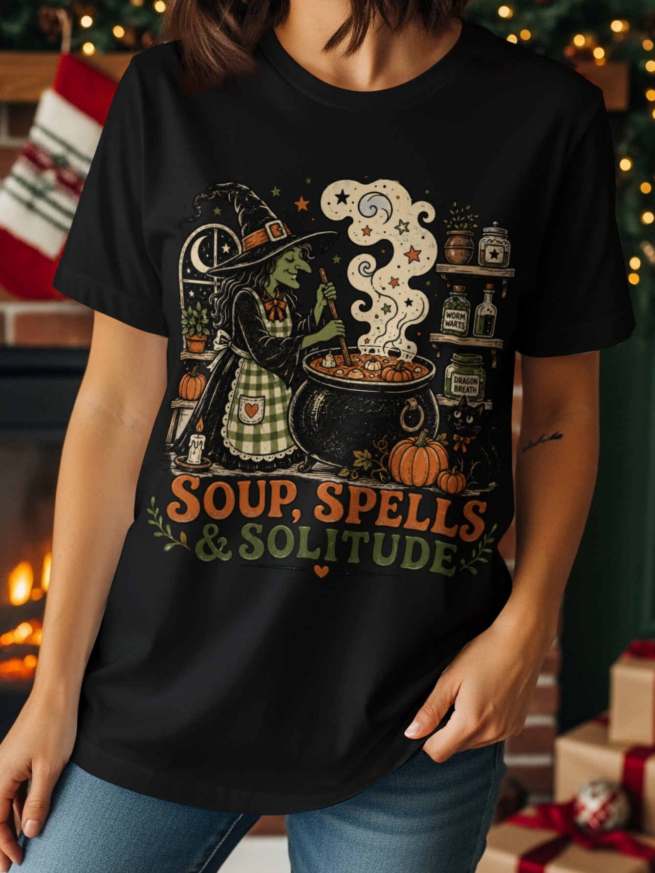 Black t-shirt with witch stirring cauldron and "Soup, Spells & Solitude" text.