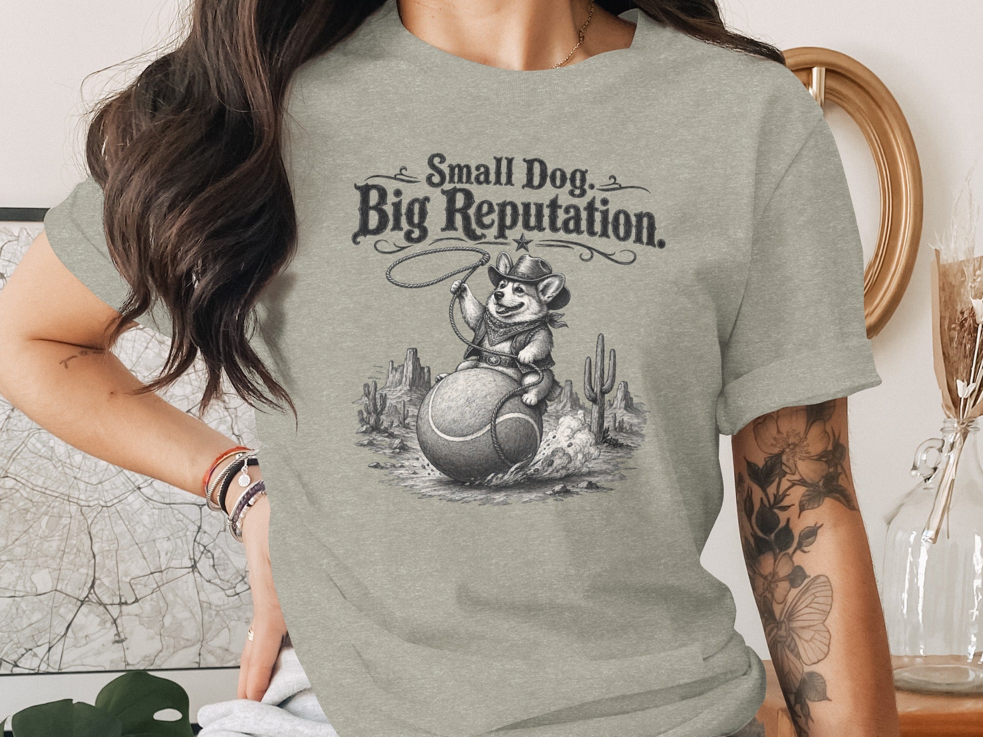T-shirt graphic: corgi cowboy on tennis ball with "Small Dog. Big Reputation." text.