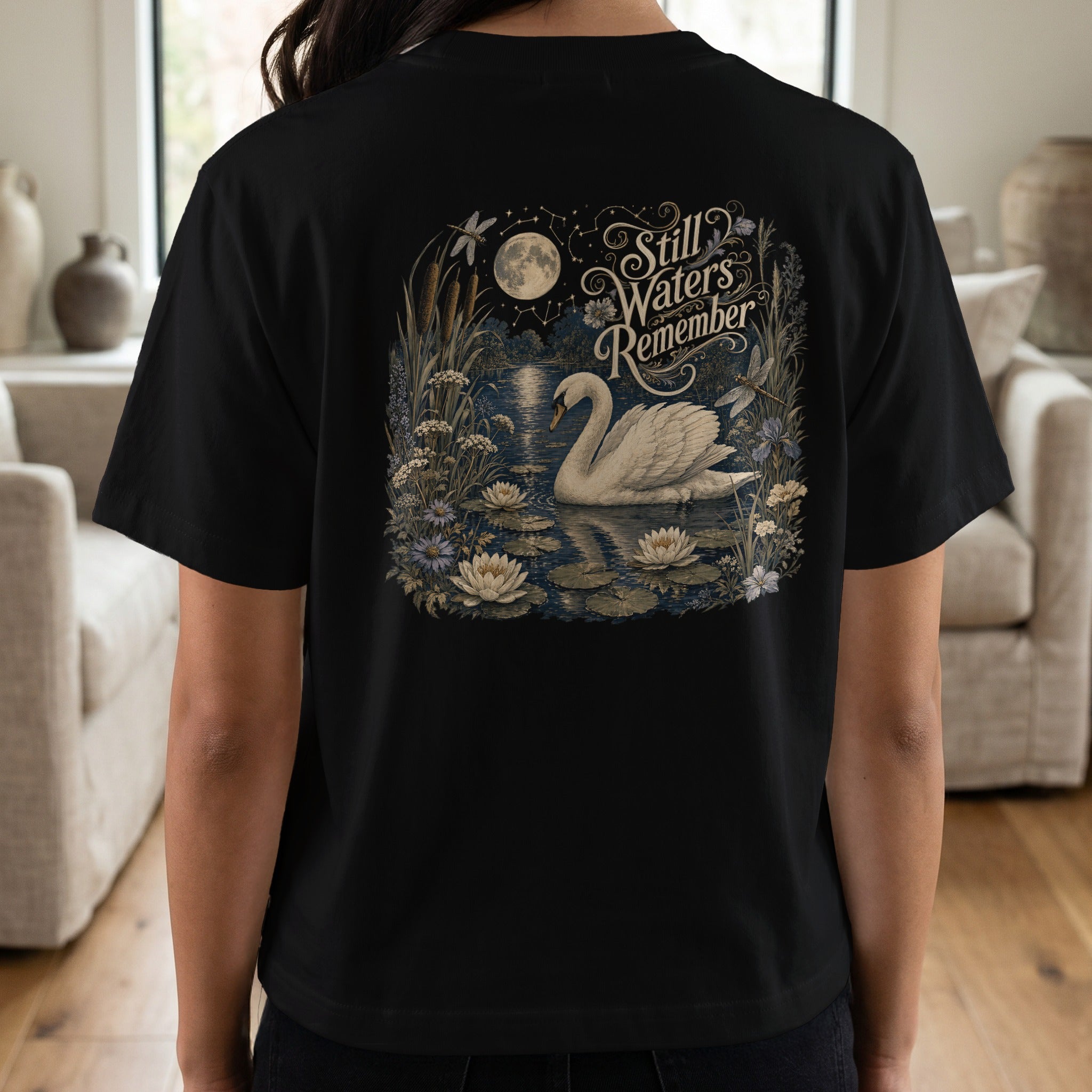 Black t-shirt with a white swan and text "Still Waters Remember" on the back.