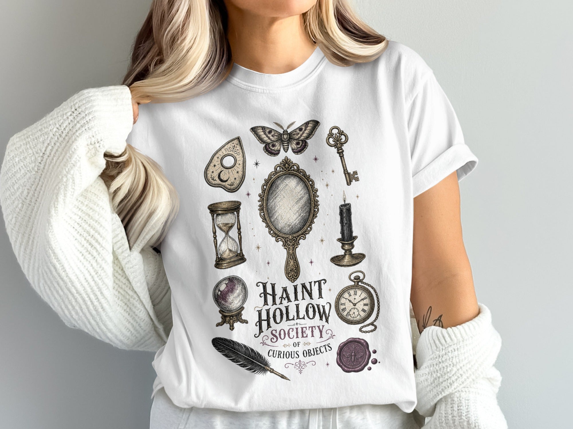 White t-shirt with "Haunt Hollow Society of Curious Objects" and vintage occult-themed graphics.
