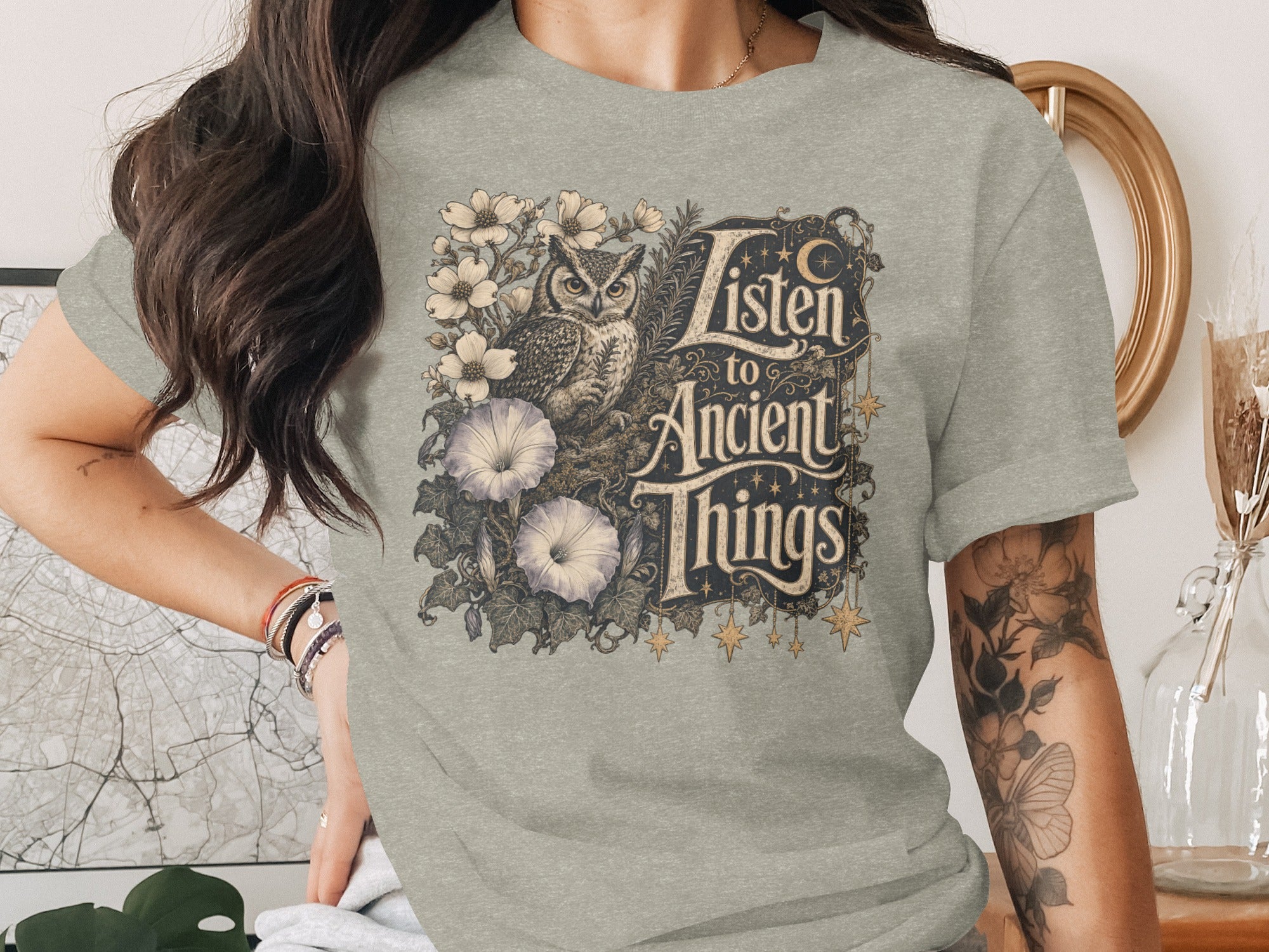 Gray t-shirt with owl, flowers, and "Listen to Ancient Things" text.