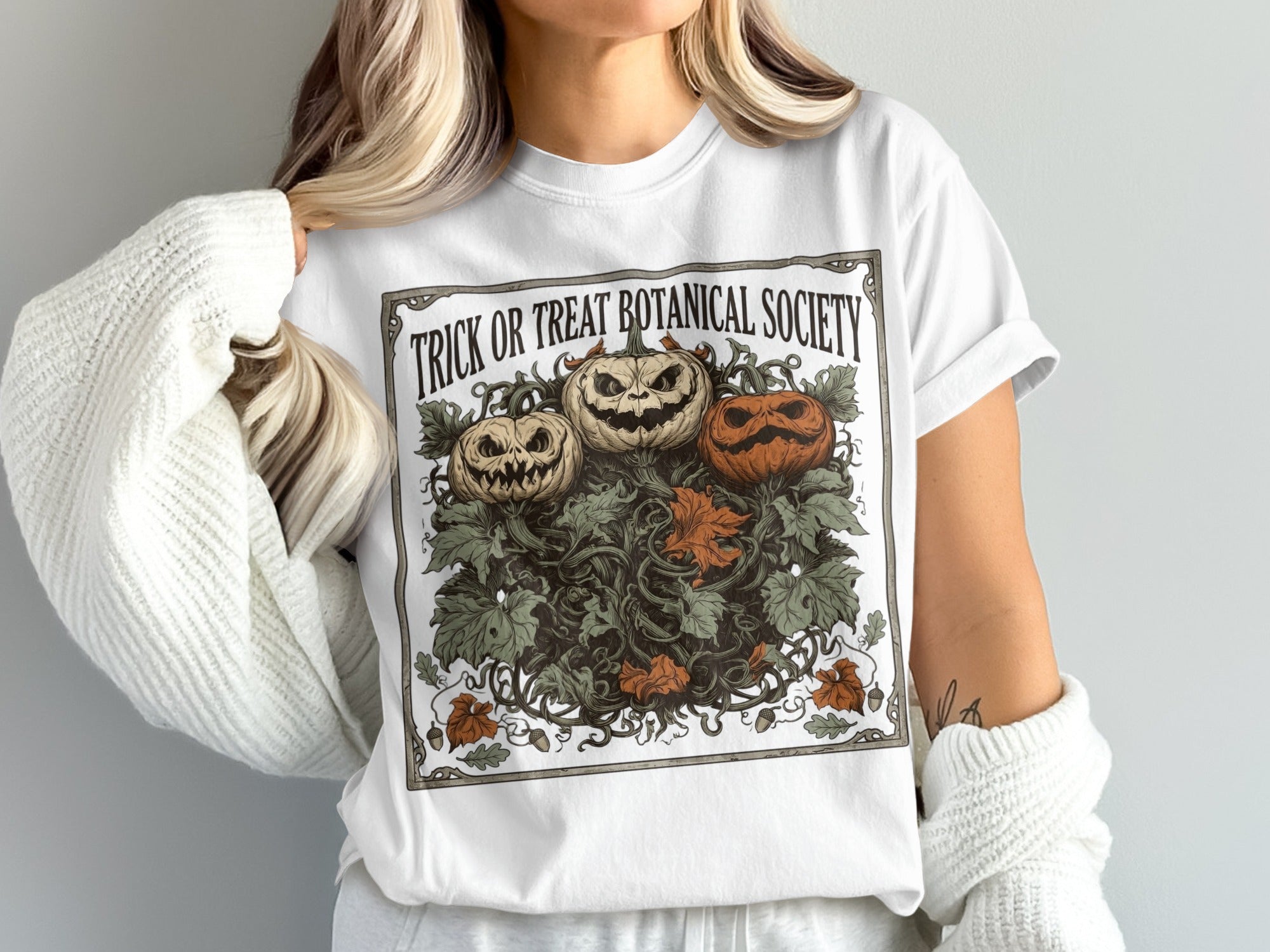 White t-shirt with "Trick or Treat Botanical Society" and a vintage pumpkin illustration.